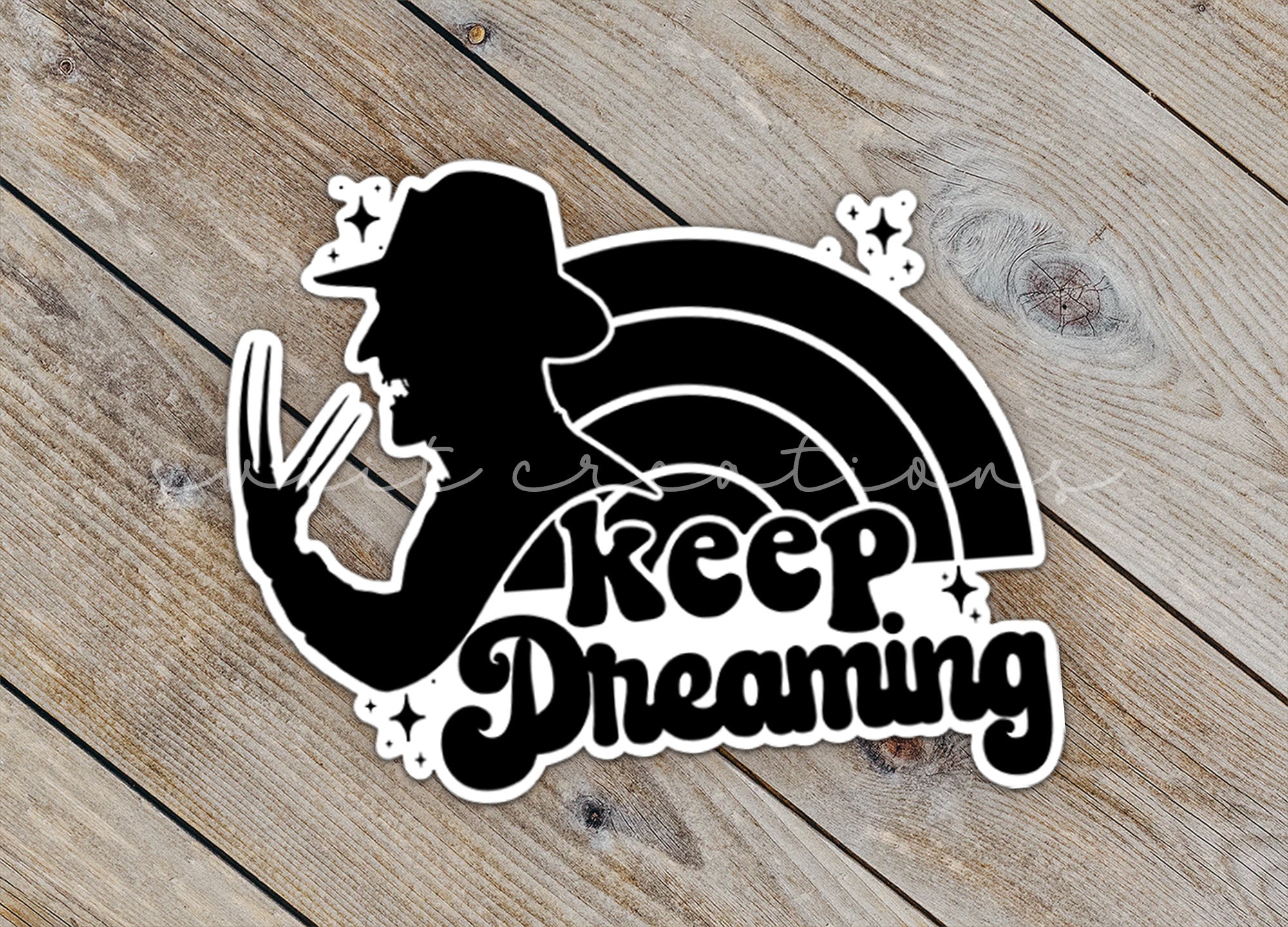a sticker that says keep dreaming on a wooden surface