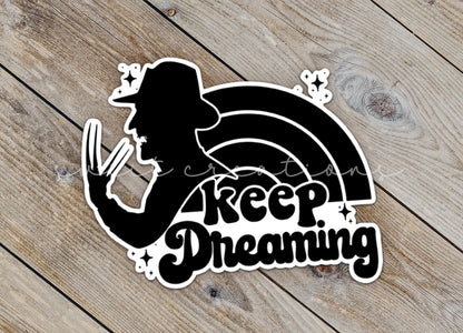 Close-up of the Keep Dreaming sticker on rustic wood