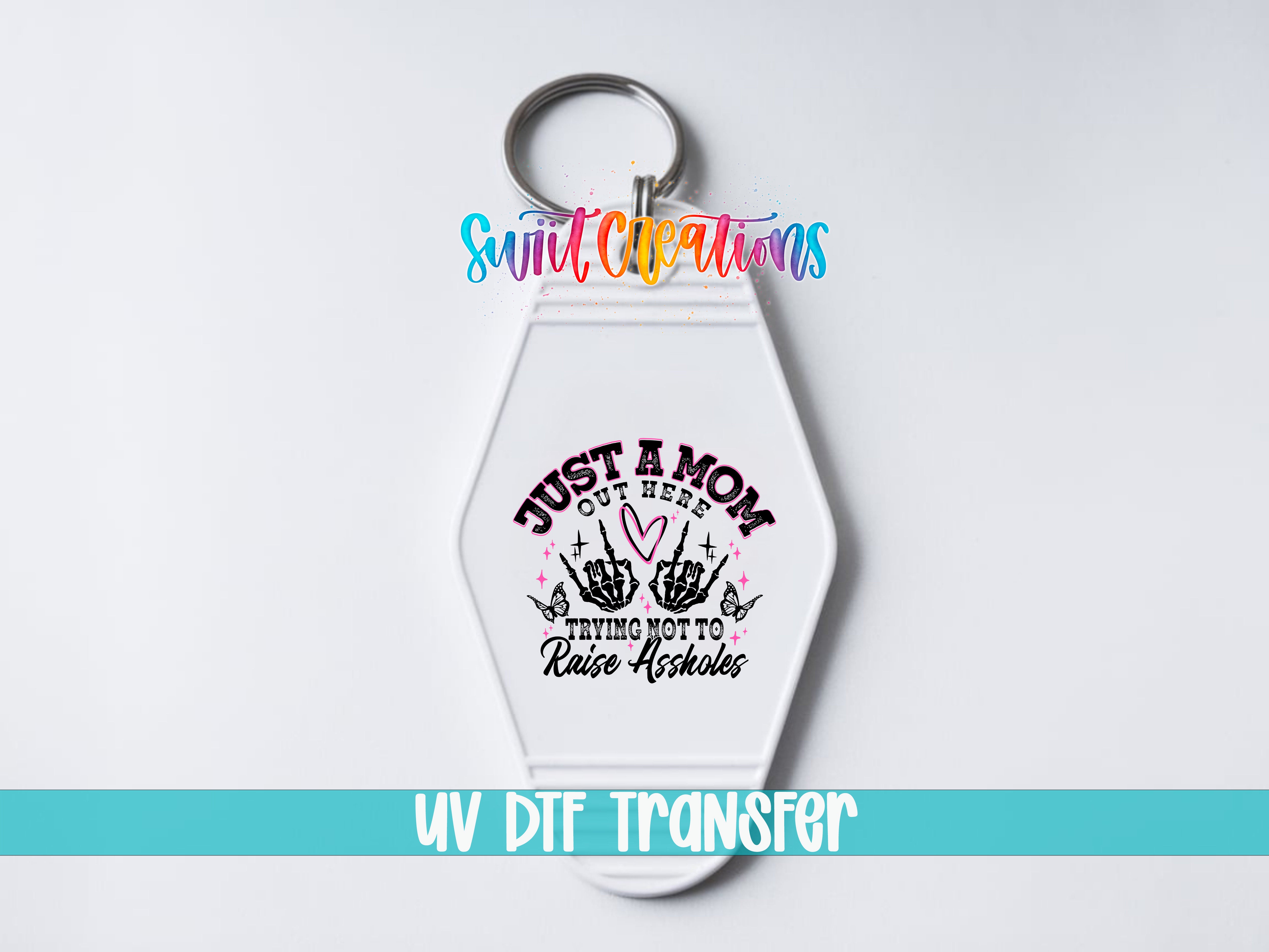 A keychain with a design featuring a skeleton hand and the text "Just a Mom, trying not to raise any hell" printed on it.
