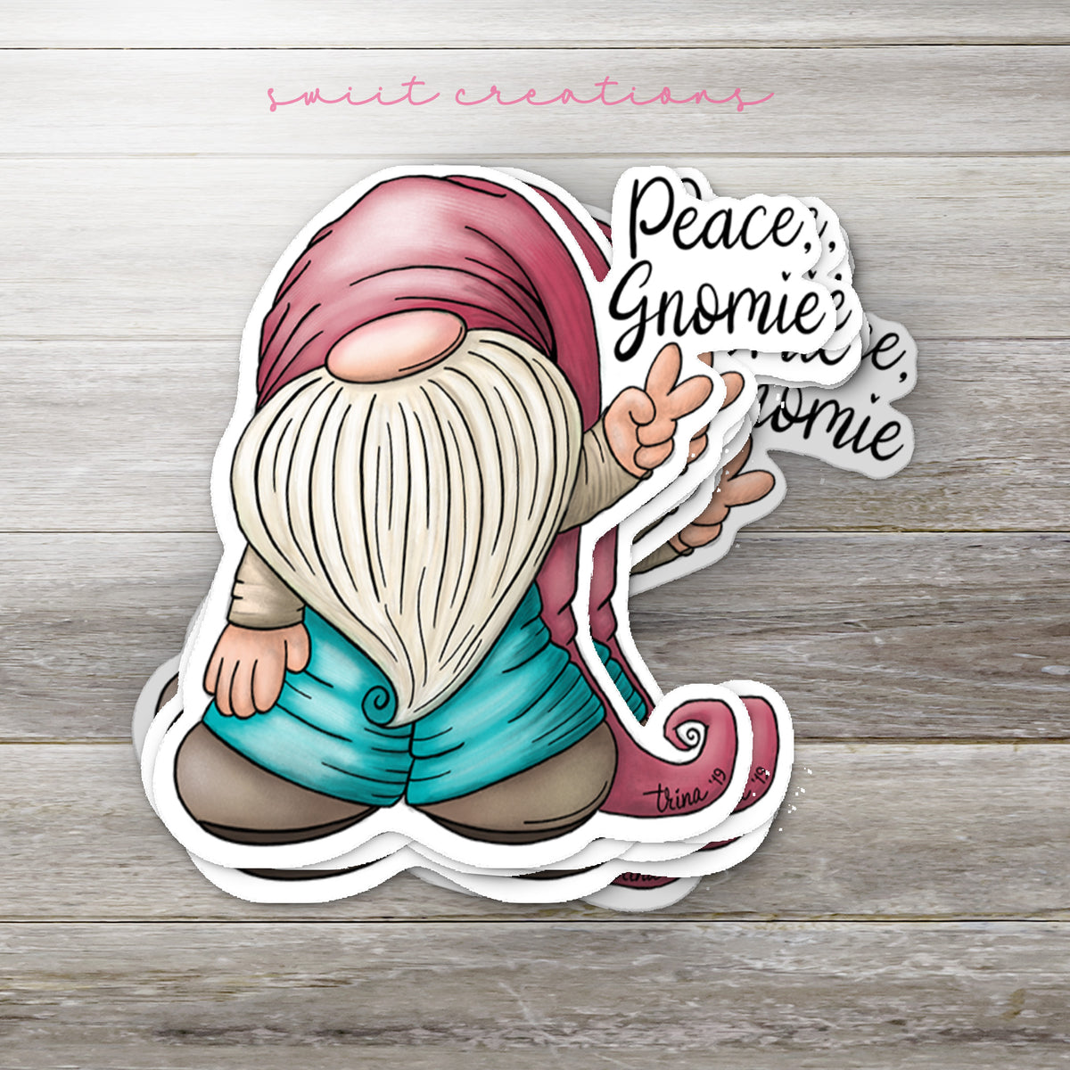 Stack of Peace Gnomie glossy stickers on a gray wood table