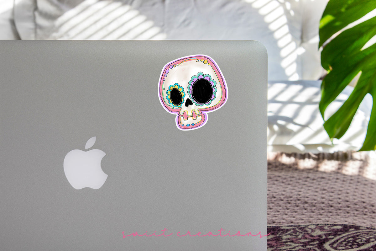 Pastel Sugar Skull sticker on the lid of a silver laptop