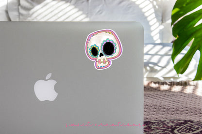 Pastel Sugar Skull sticker on the lid of a silver laptop