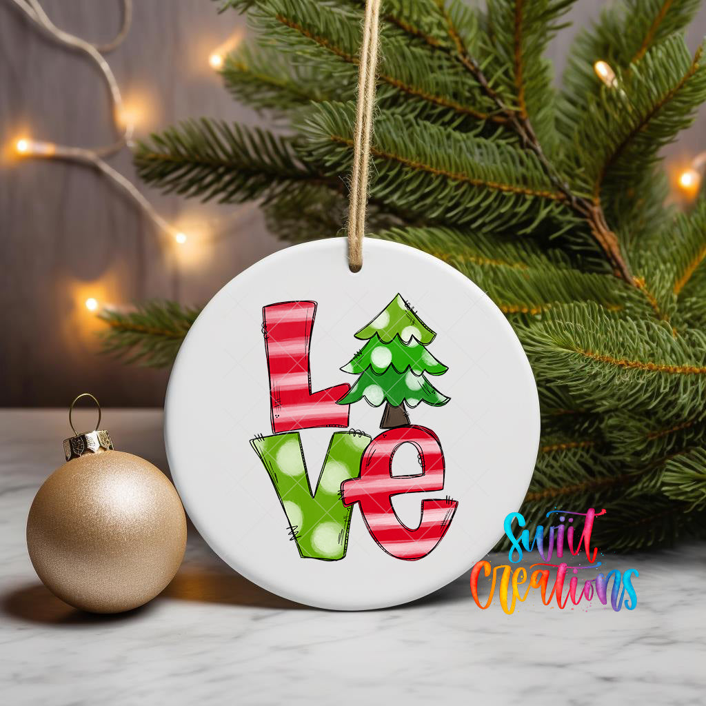 A white ceramic ornament with the word "LOVE" written in a colorful, hand-drawn style, surrounded by a Christmas tree and a gold ornament.