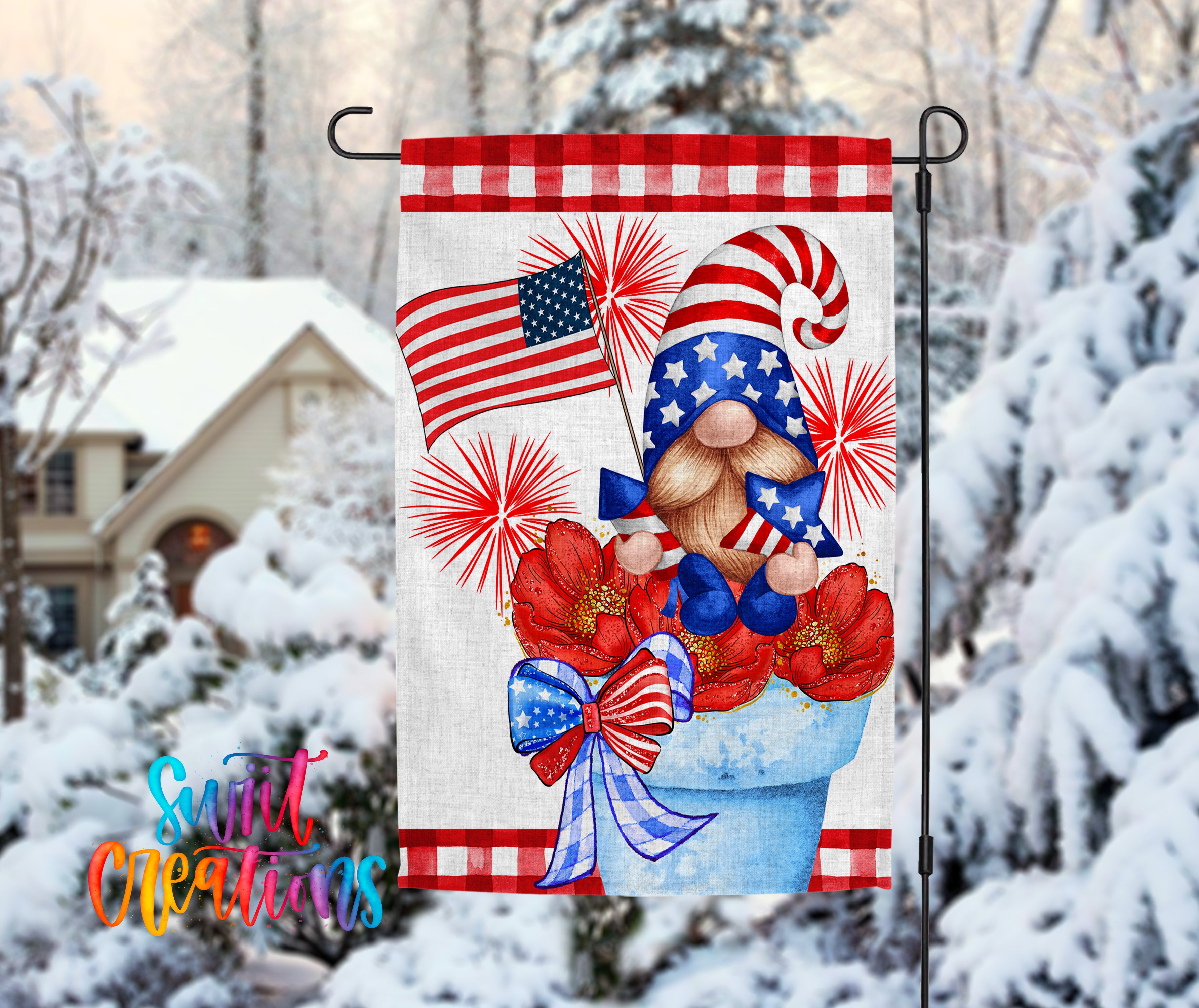 A patriotic-themed garden flag featuring a gnome holding an American flag and surrounded by red and white flowers, set against a snowy winter landscape with a house in the background.