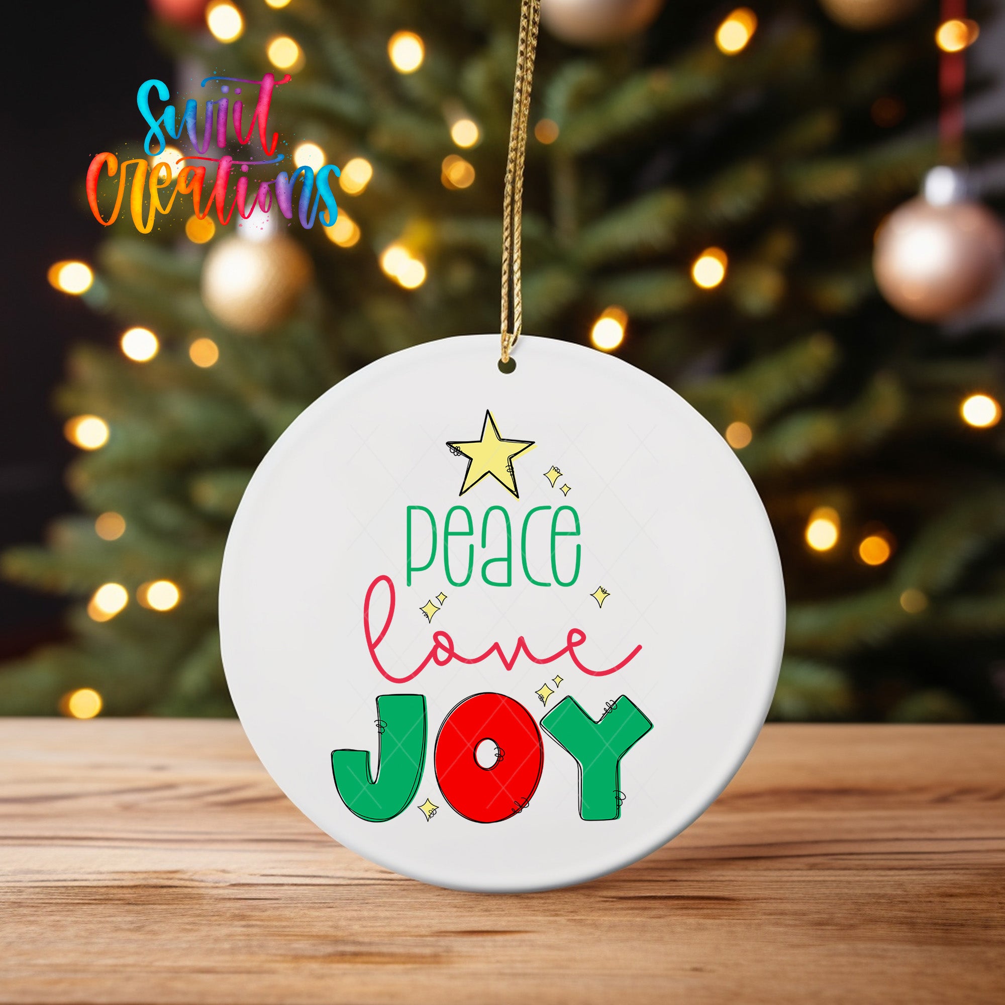 A white ceramic ornament with the text "Peace love joy" and a star decoration, hanging on a string.