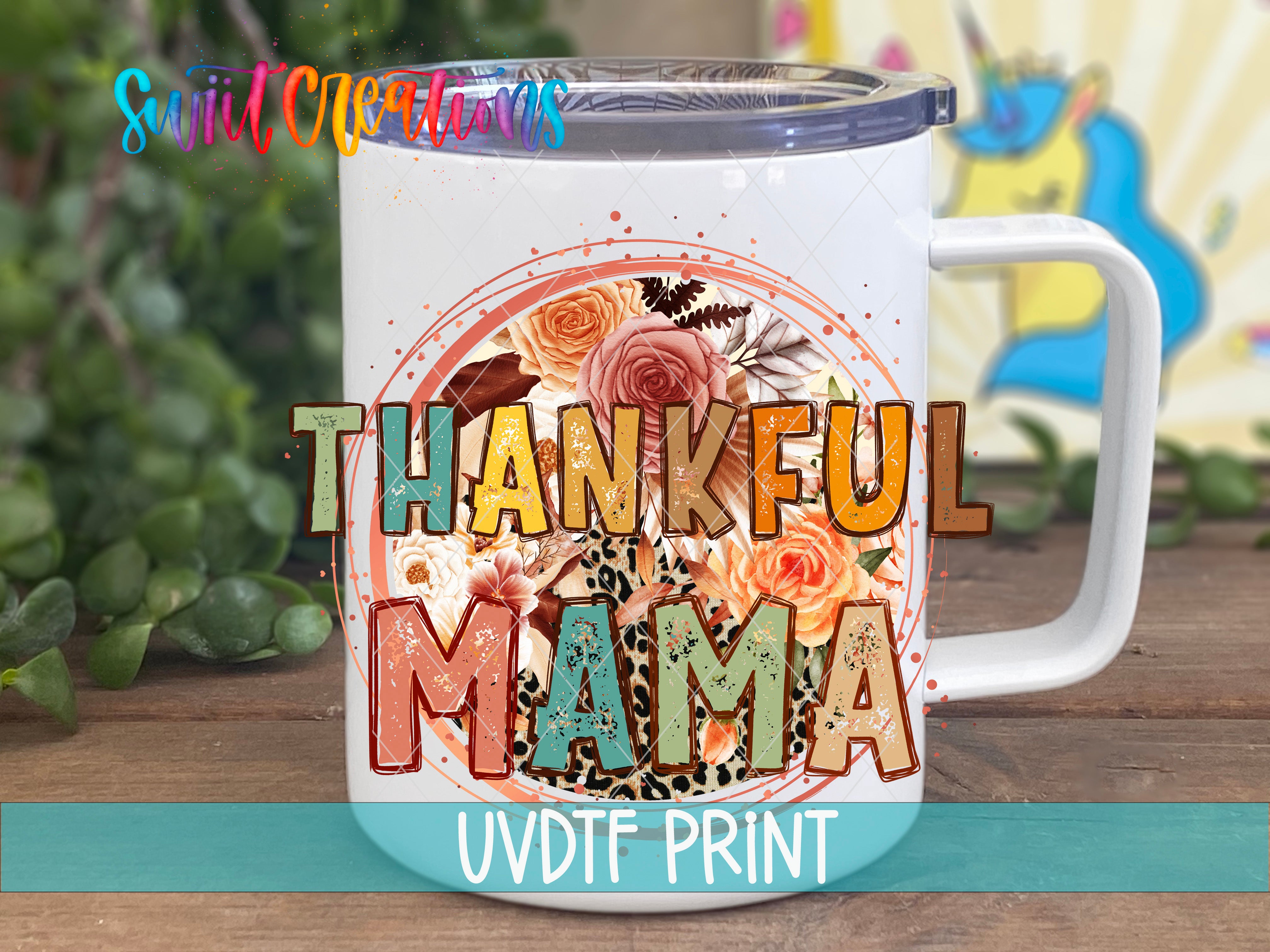 A white ceramic mug with a colorful floral design and the text "THANKFUL MAMA" printed on it.