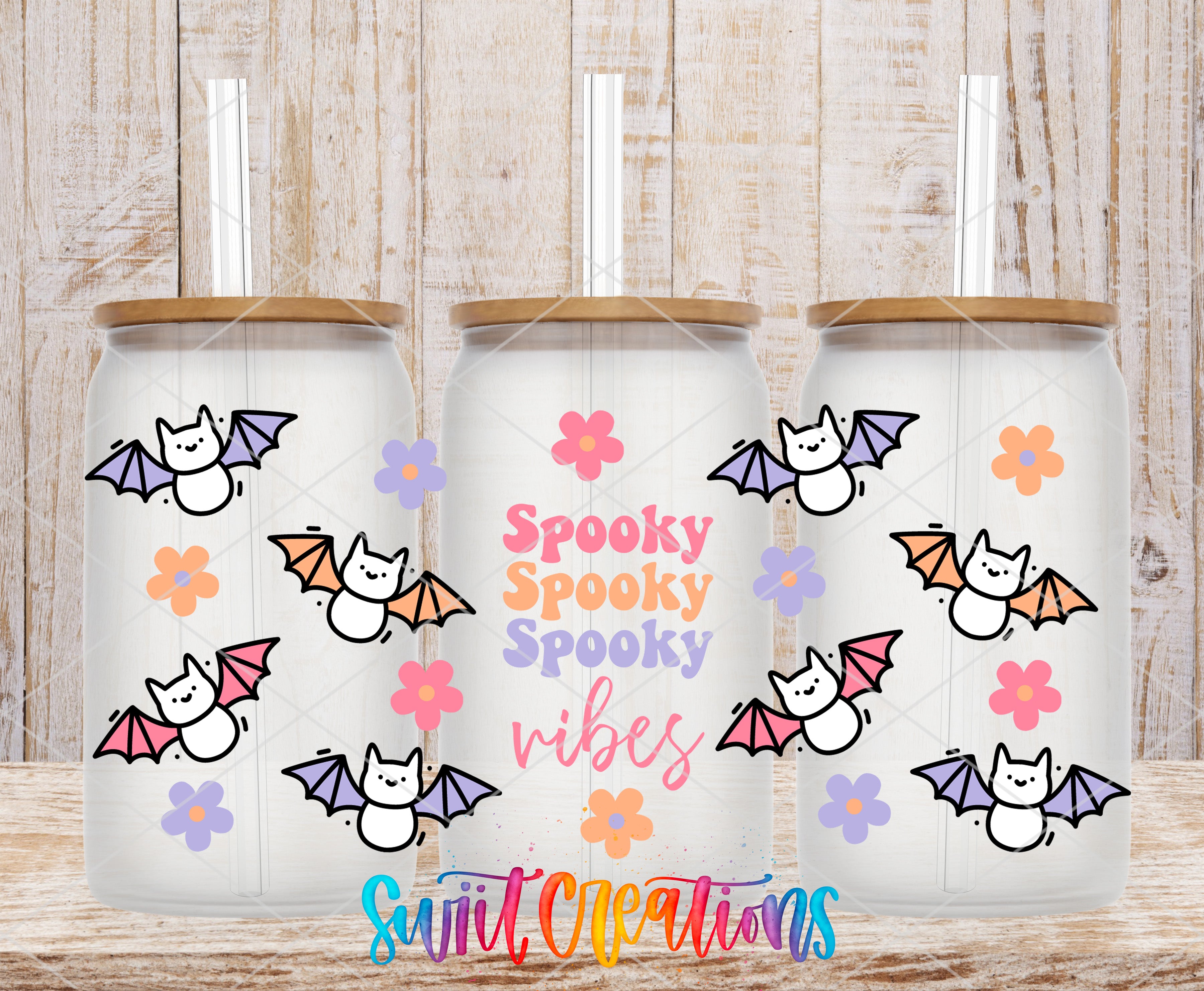 three glass tumblers with a spooky bat theme. Each tumbler has a straw and is decorated with bats, flowers, and the text "Spooky Spooky Vibes" in a playful and whimsical style.