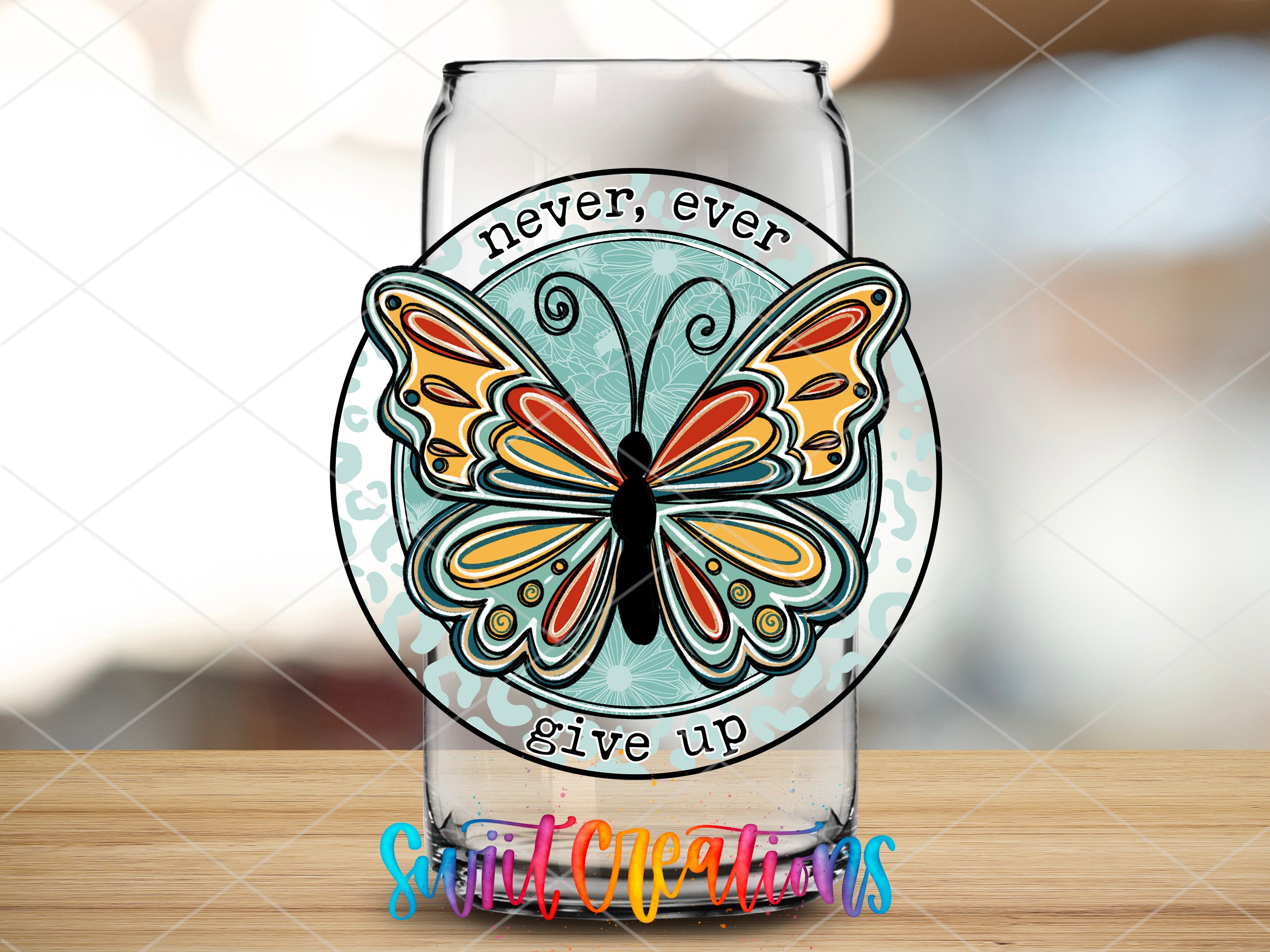 a glass with a butterfly on it sitting on a table