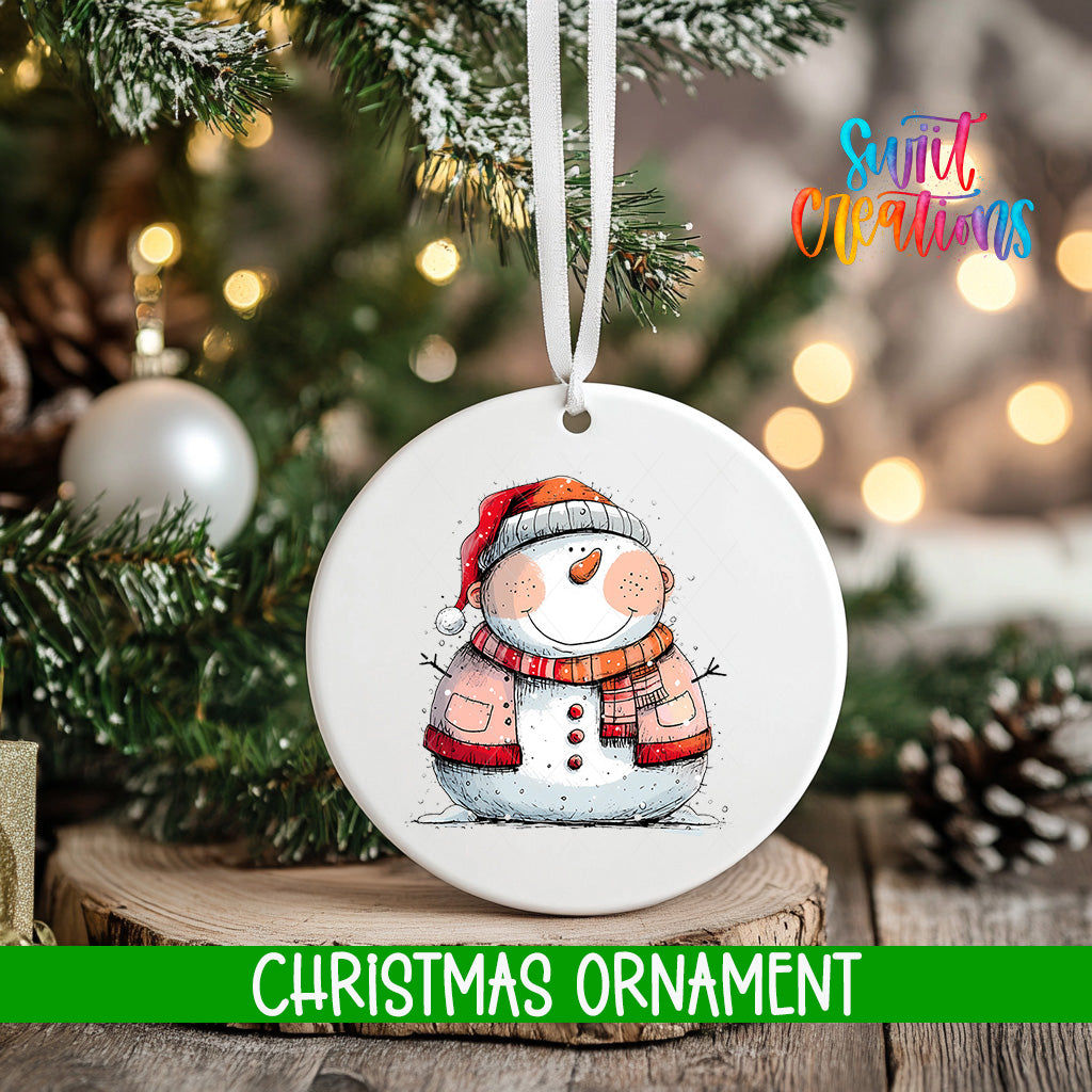 A white Christmas ornament featuring a snowman is hanging from a tree branch, with a blurred background of pine branches and twinkling lights.