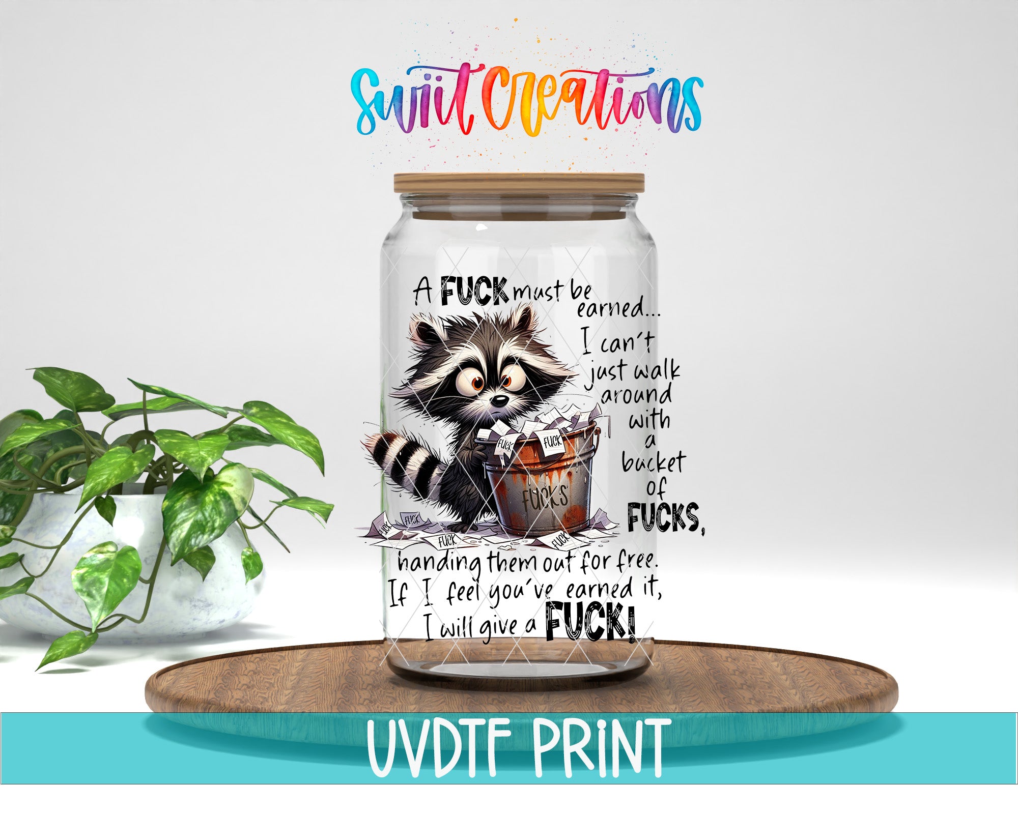 A jar with a raccoon graphic and text, placed on a wooden surface next to a potted plant.