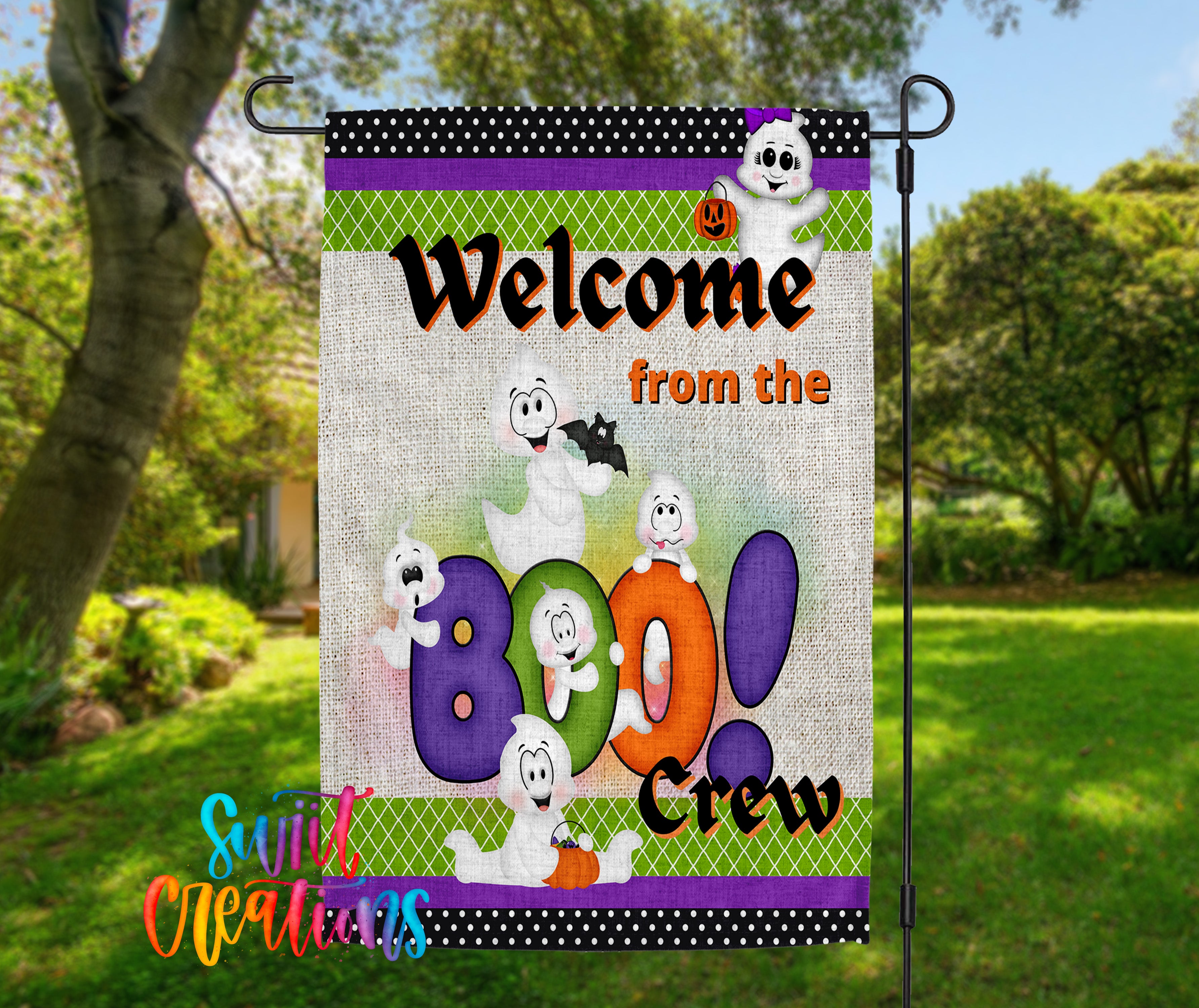A colorful garden sign with a cartoon ghost character and the text "Welcome from the Boo Crew" displayed in a park setting.