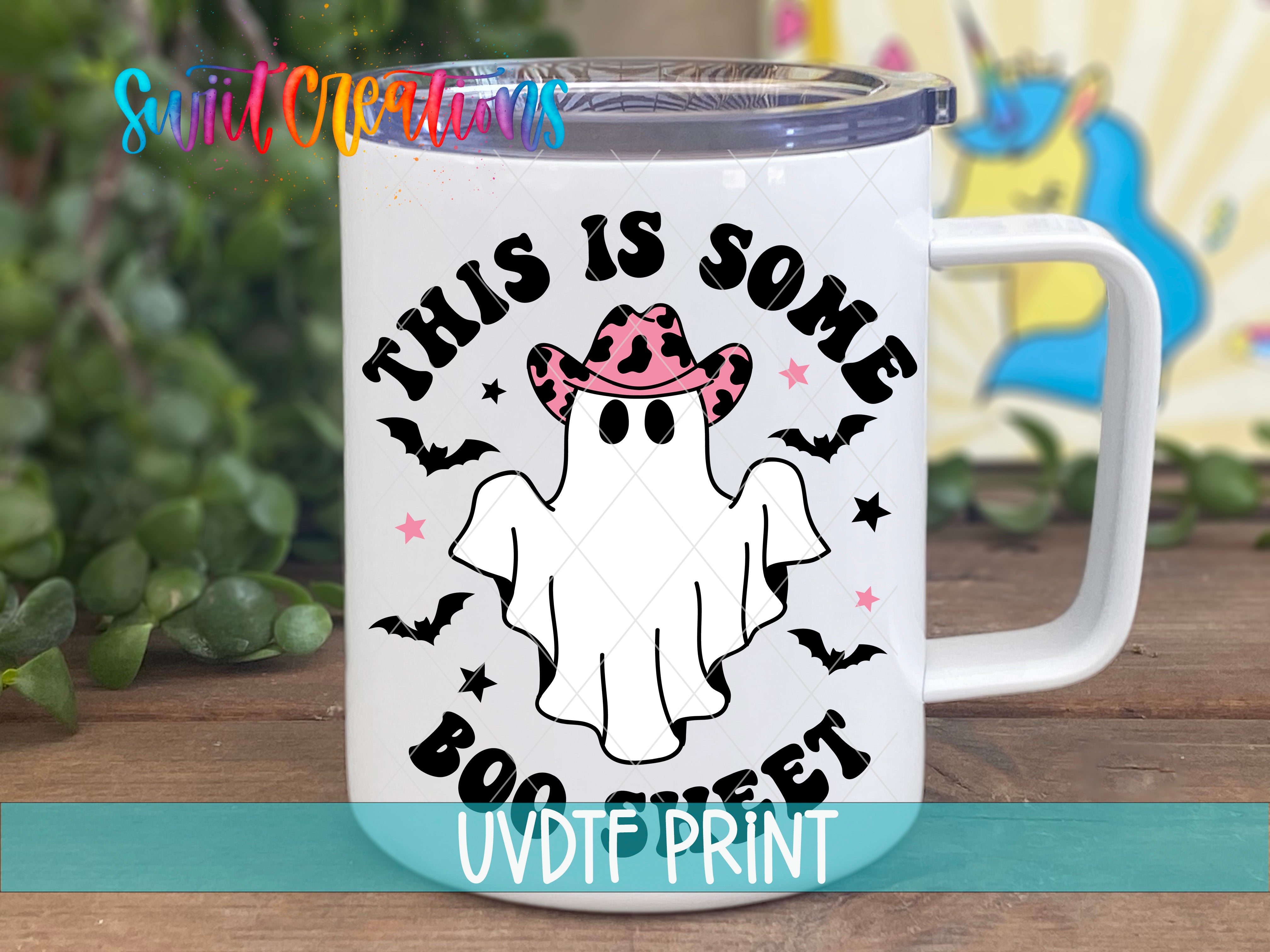 A white mug with a graphic design featuring a ghost wearing a cowboy hat and surrounded by bats and stars.