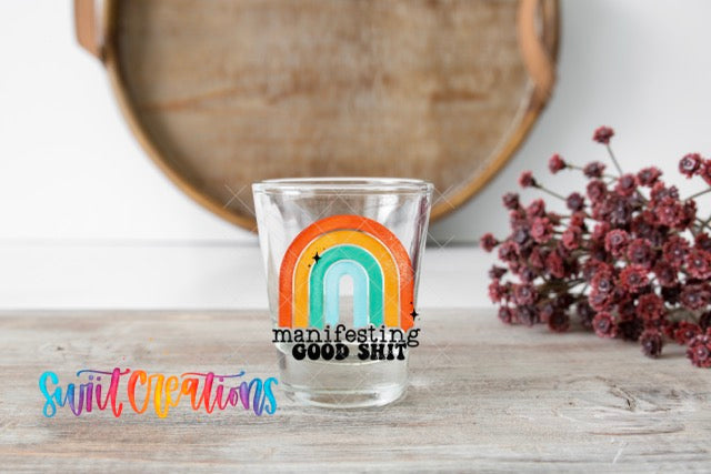 a shot glass with a rainbow sticker on it