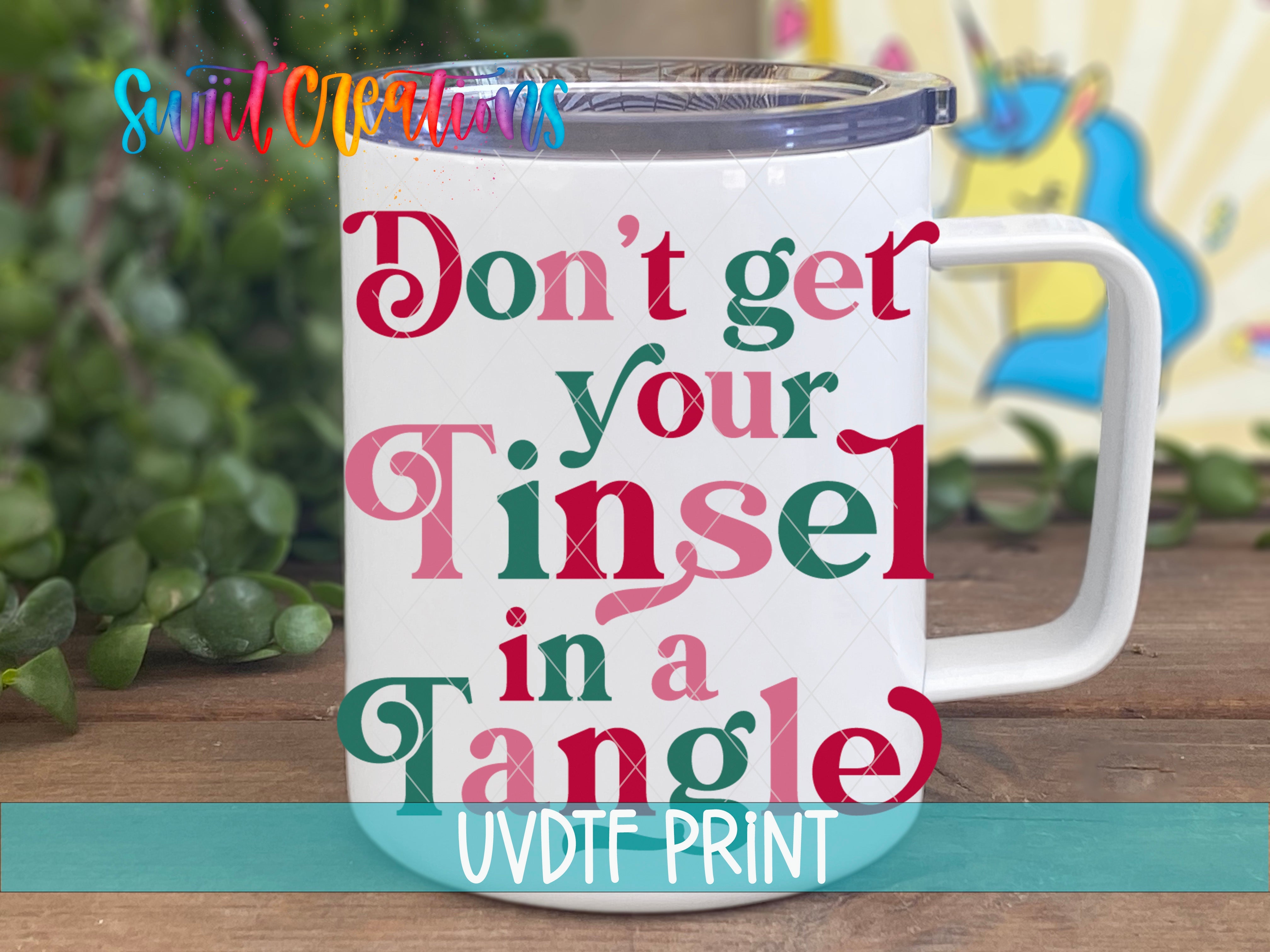a coffee mug with the words don't get your tinsel in a tangle