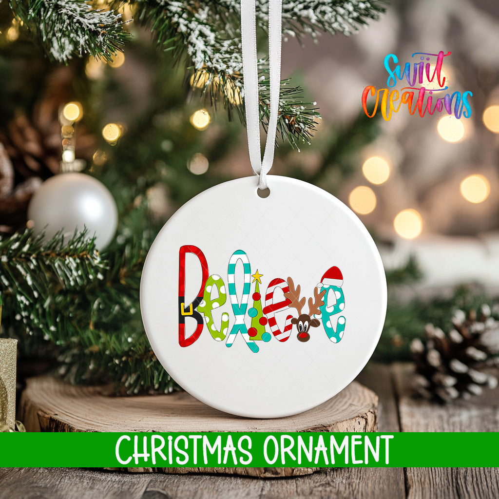 A white Christmas ornament with the word "Believe" written on it, hanging from a tree branch.