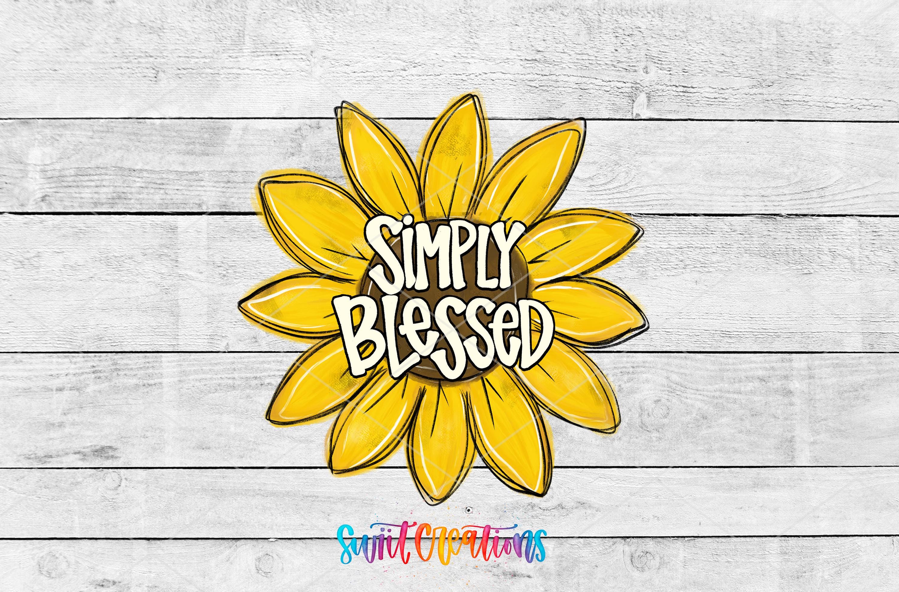 a large yellow sunflower with the text "Simply Blessed" written on it, set against a white wooden background.