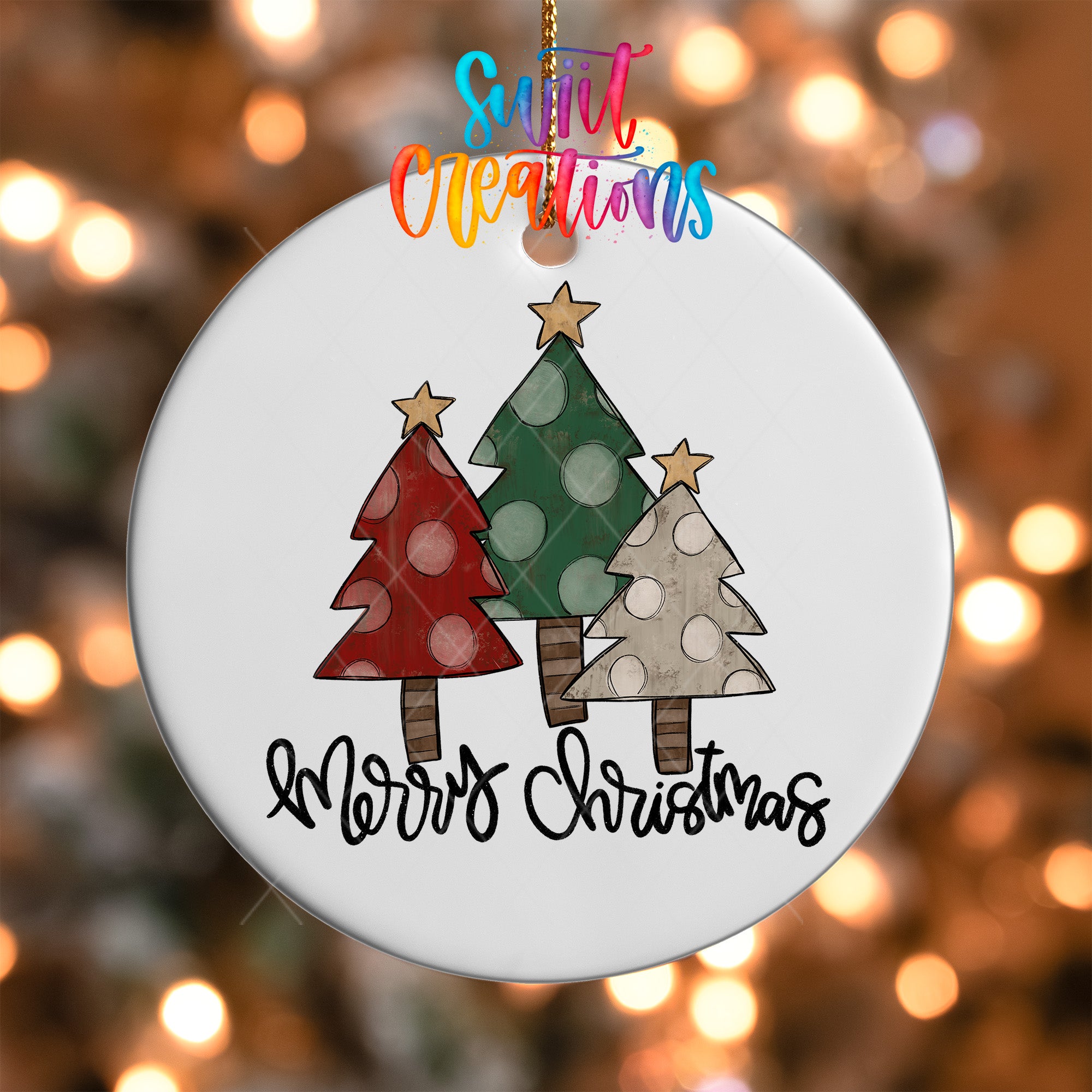 A white Christmas ornament with three colorful Christmas trees and the text "Merry Christmas" written on it.