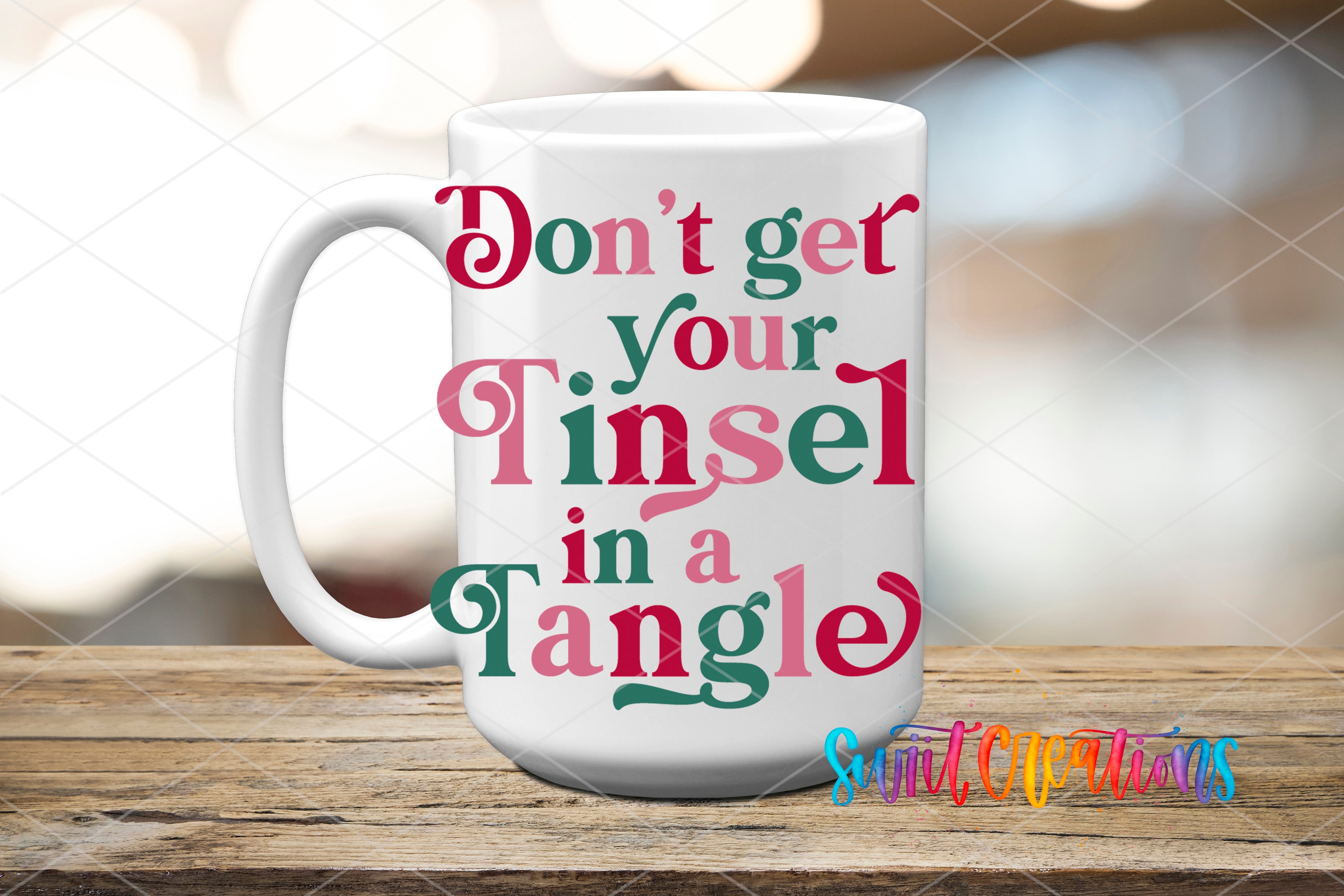 A white mug with a colorful text design on it, placed on a wooden surface.