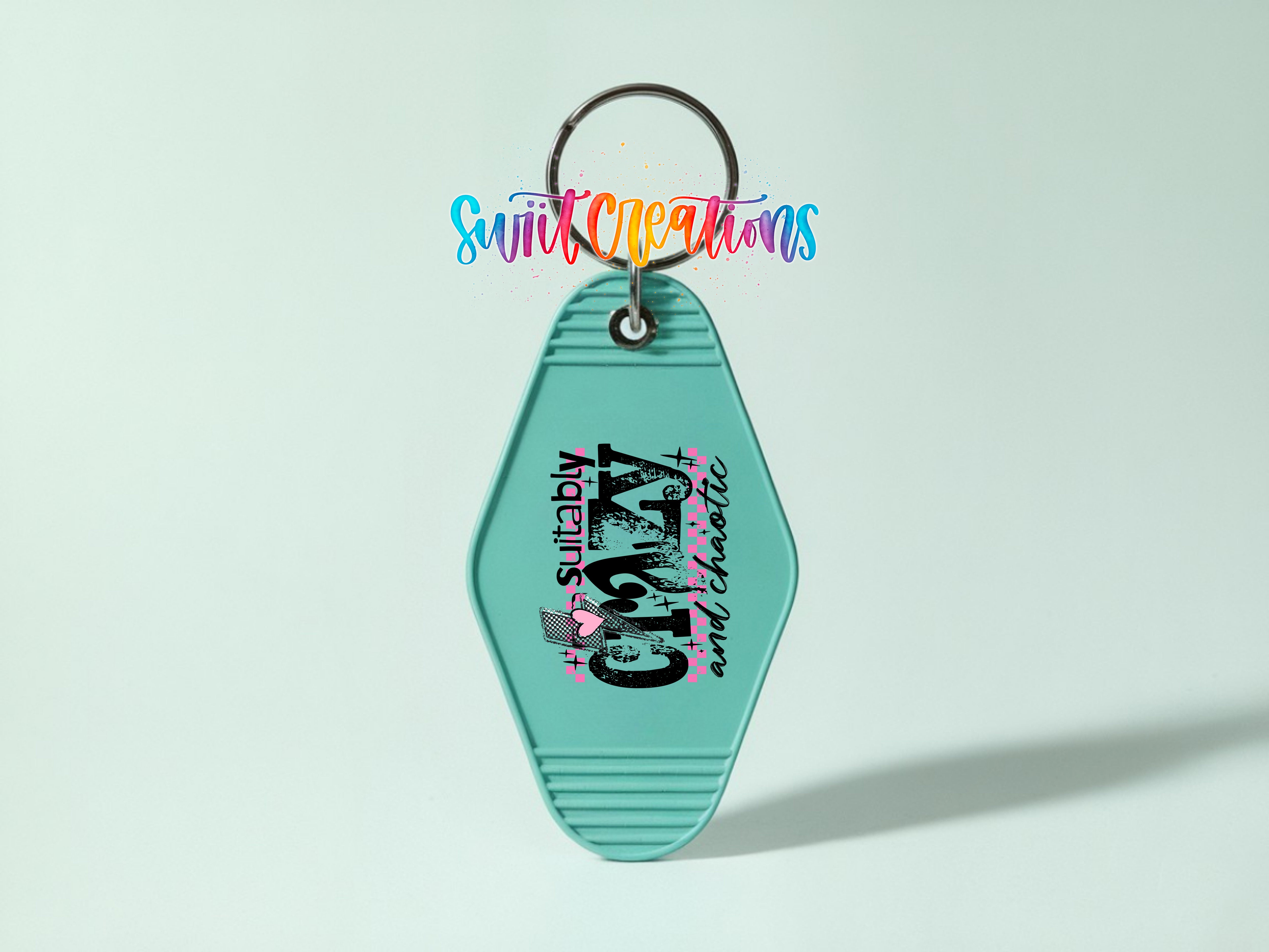 A turquoise keychain with a colorful design and text on it.