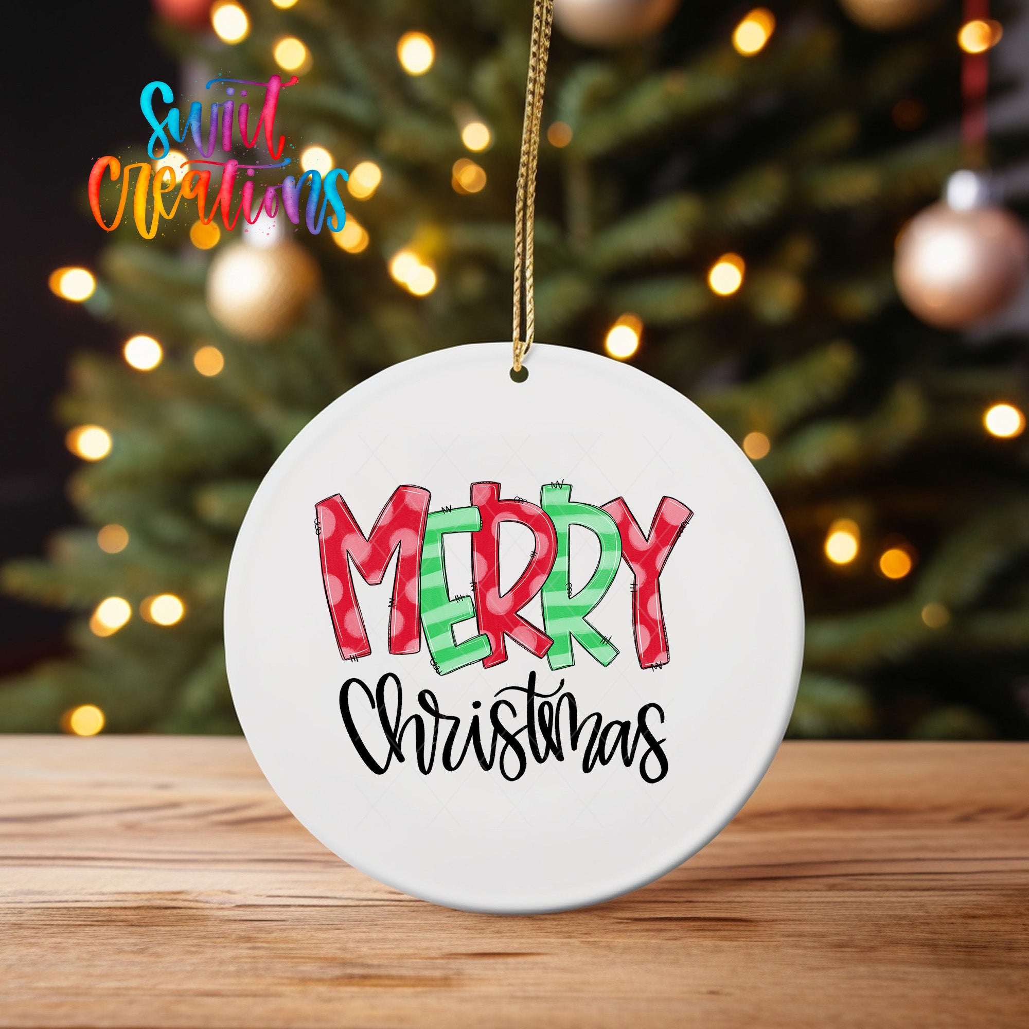 A white ceramic ornament with the text "MERRY CHRISTMAS" written on it, hanging from a string.