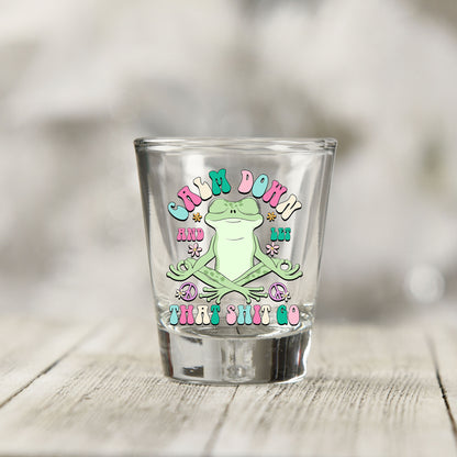 Close-up of the Calm Down And Let That Sh*t Go UV DTF transfer on a clear shot glass