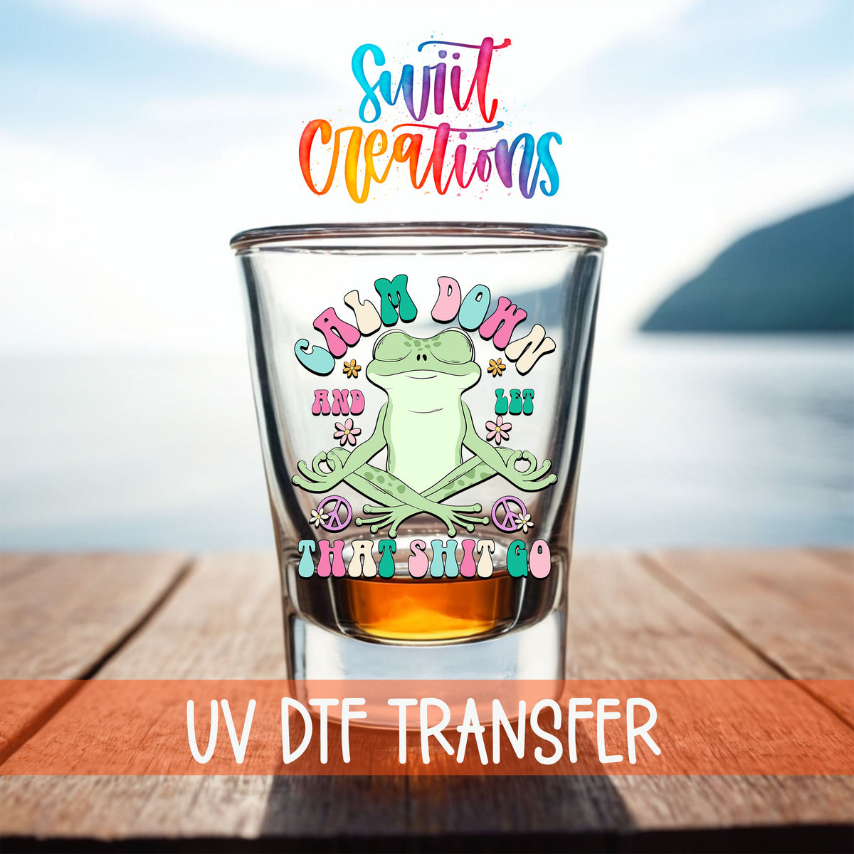 Calm Down And Let That Sh*t Go shot glass UV DTF transfer on a filled shot glass on a dock by the water