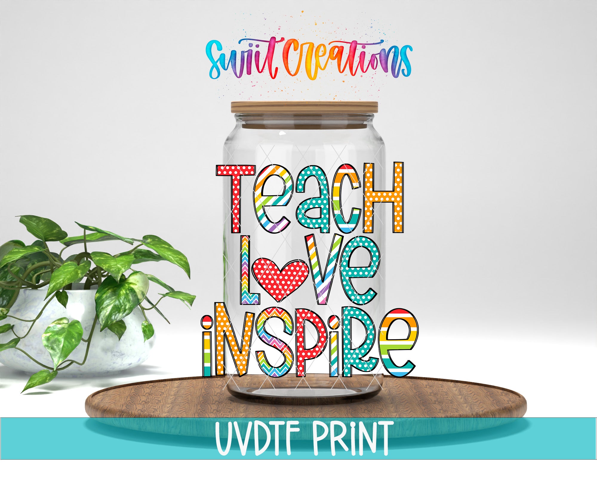 a large glass jar with colorful text on it, placed on a wooden surface. The text on the jar reads "Teach Love Inspire".