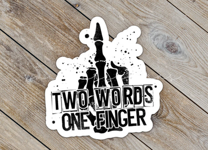 Close-up of the Two Words One Finger sticker on rustic wood