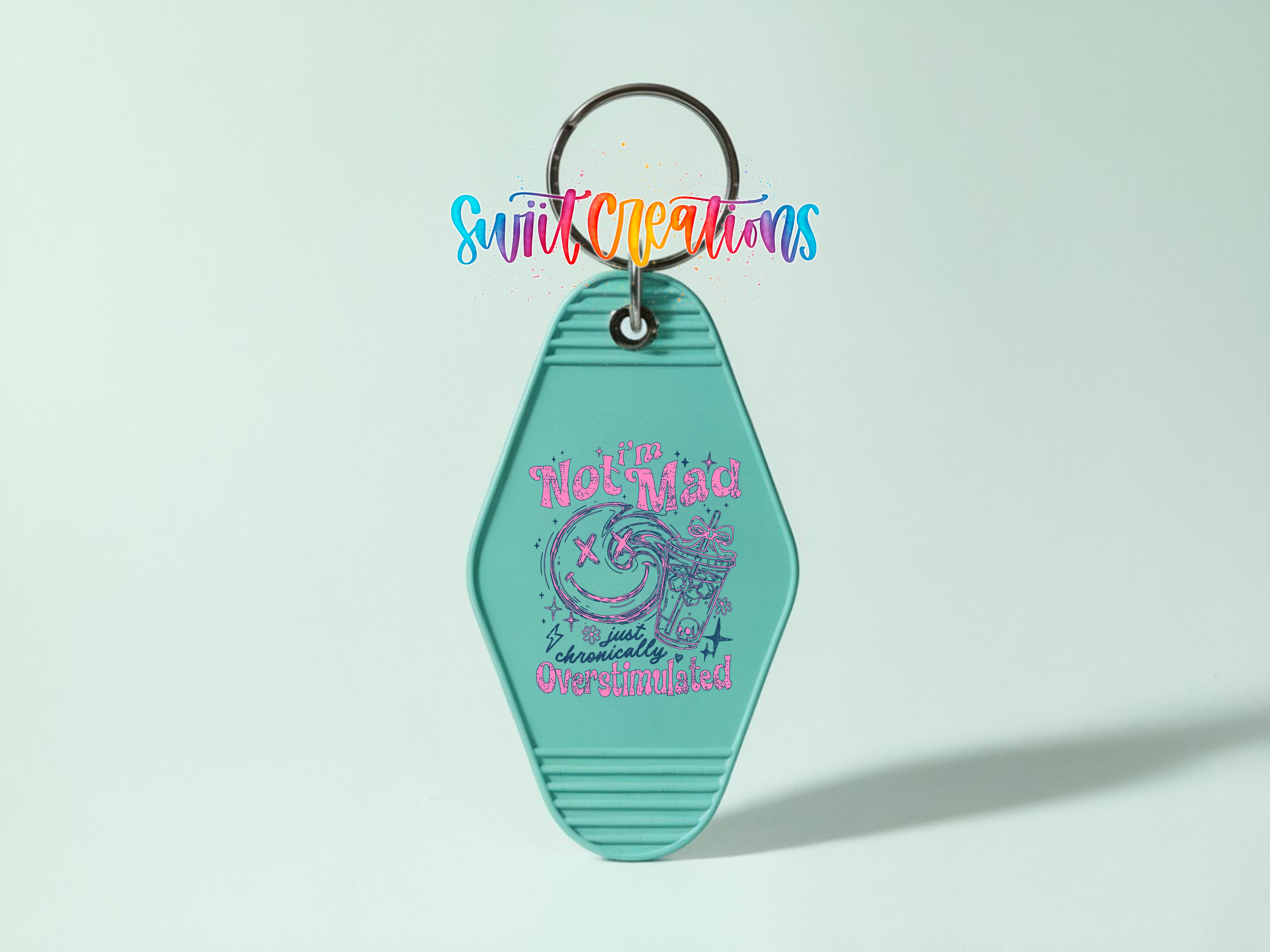 A turquoise keychain with a colorful design and text on it.