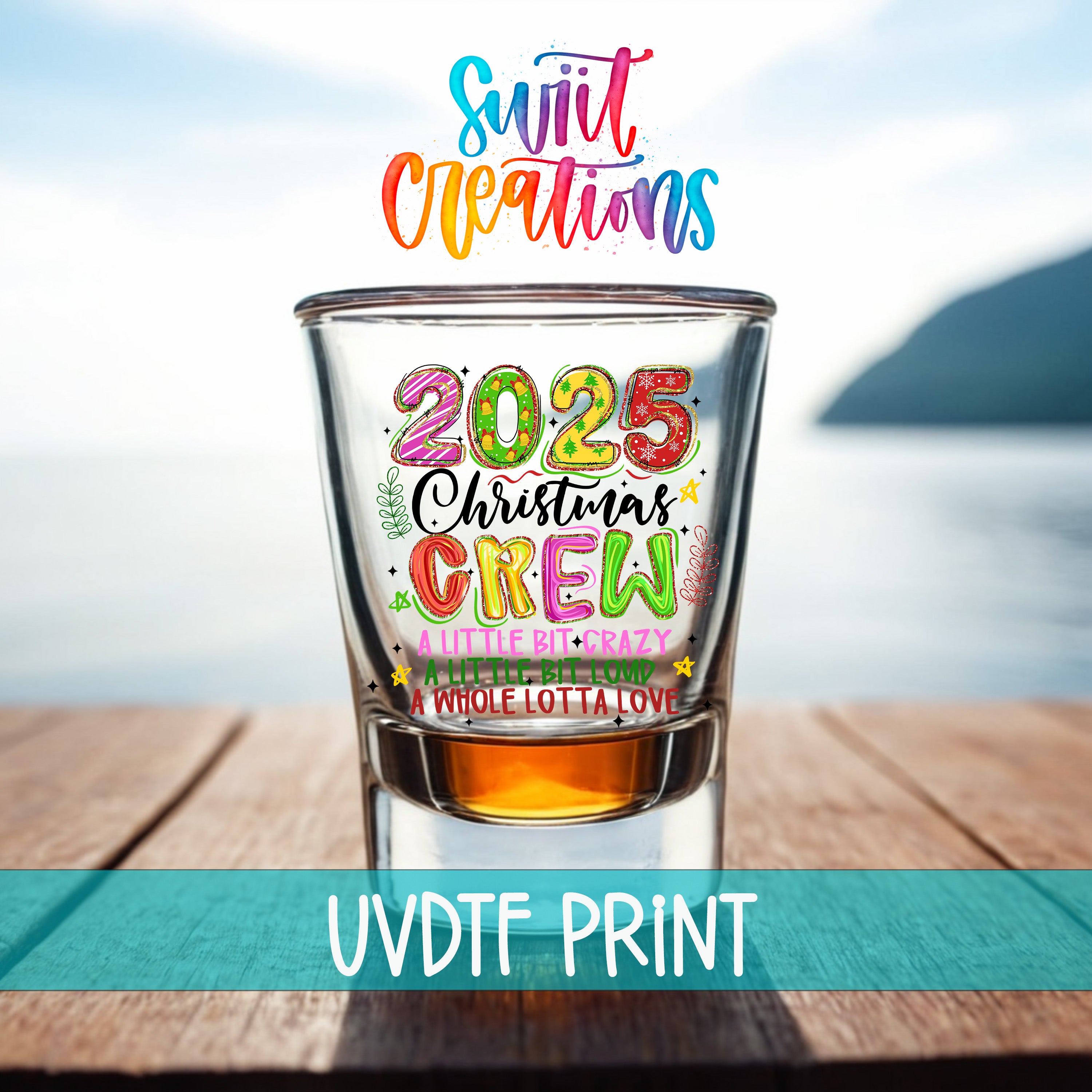 A colorful glass tumbler with the text "Sweet Capitations" and "2025 Christmas Crew" printed on it, placed on a wooden surface with a body of water in the background.