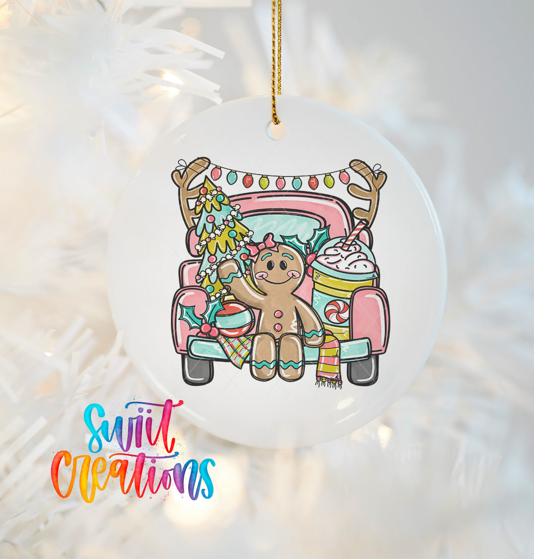 A white ornament with a gingerbread man and Christmas decorations hanging from a string.