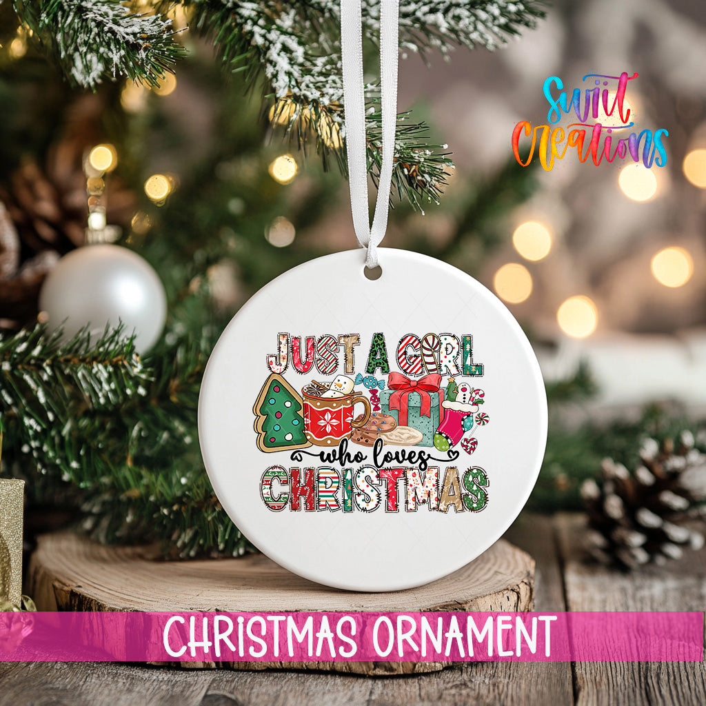 A white Christmas ornament with the text "Just a girl who loves Christmas" is hanging from a tree branch.