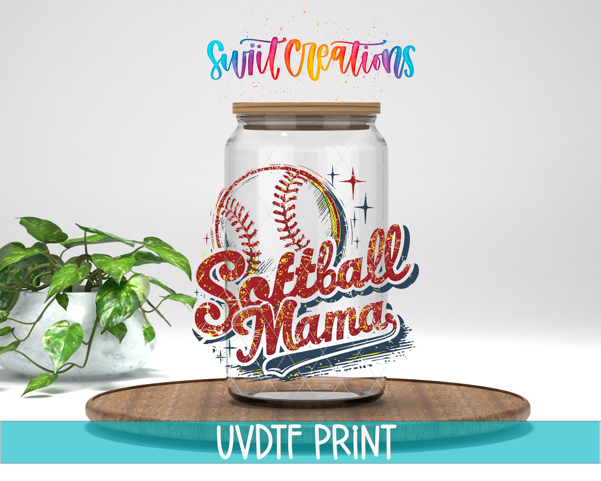 A glass jar with a baseball design and the text "Softball Mama" printed on it, placed on a wooden surface.