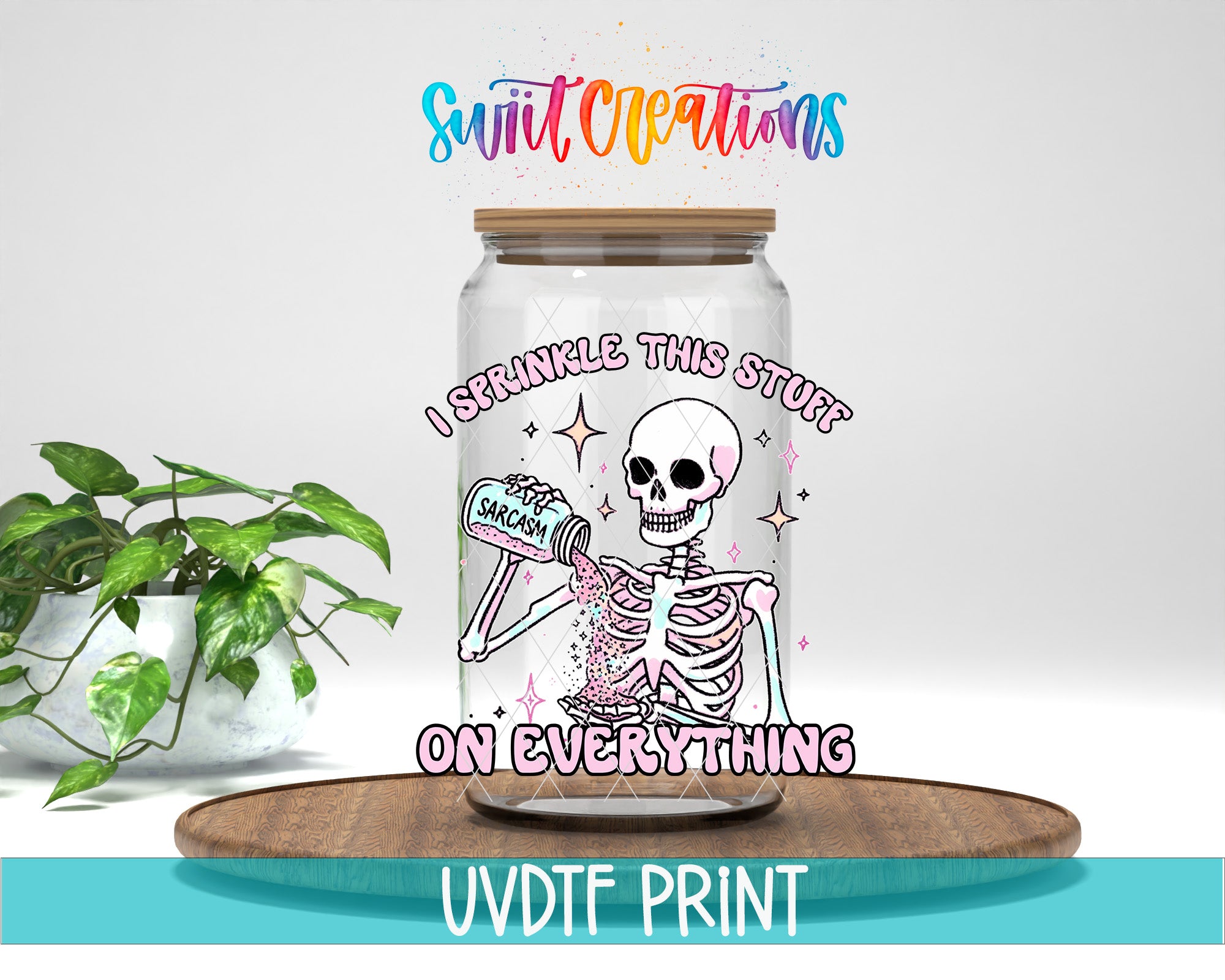 A glass jar with a skeleton holding a bottle of sprinkles, accompanied by text that reads "I sprinkle this stuff on everything" and "Swift Creations". The jar is placed on a wooden surface, and there is a plant in the background.