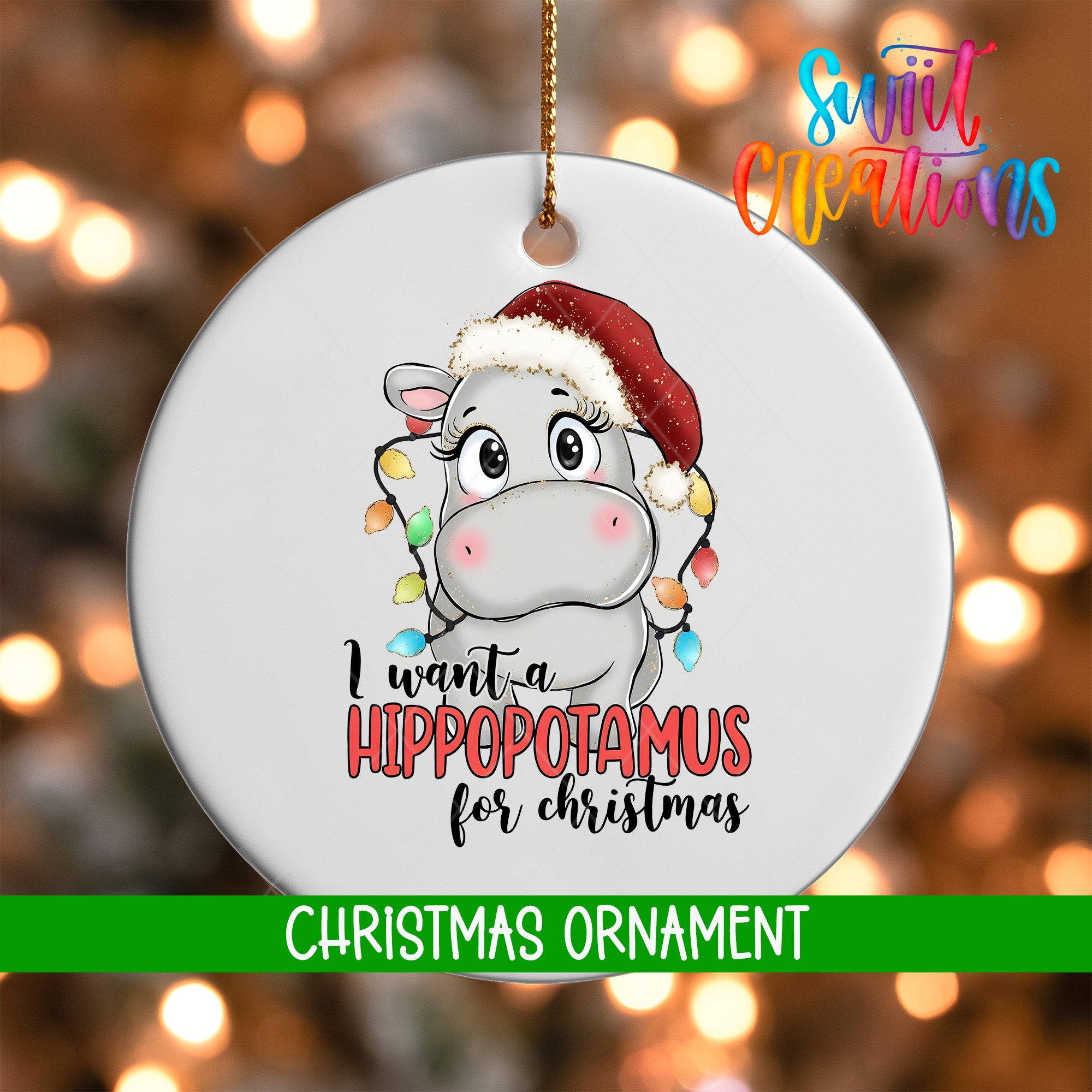 A white ornament with a cartoon image of a hippopotamus wearing a Santa hat and the text "I want a Hippopotamus for Christmas"
