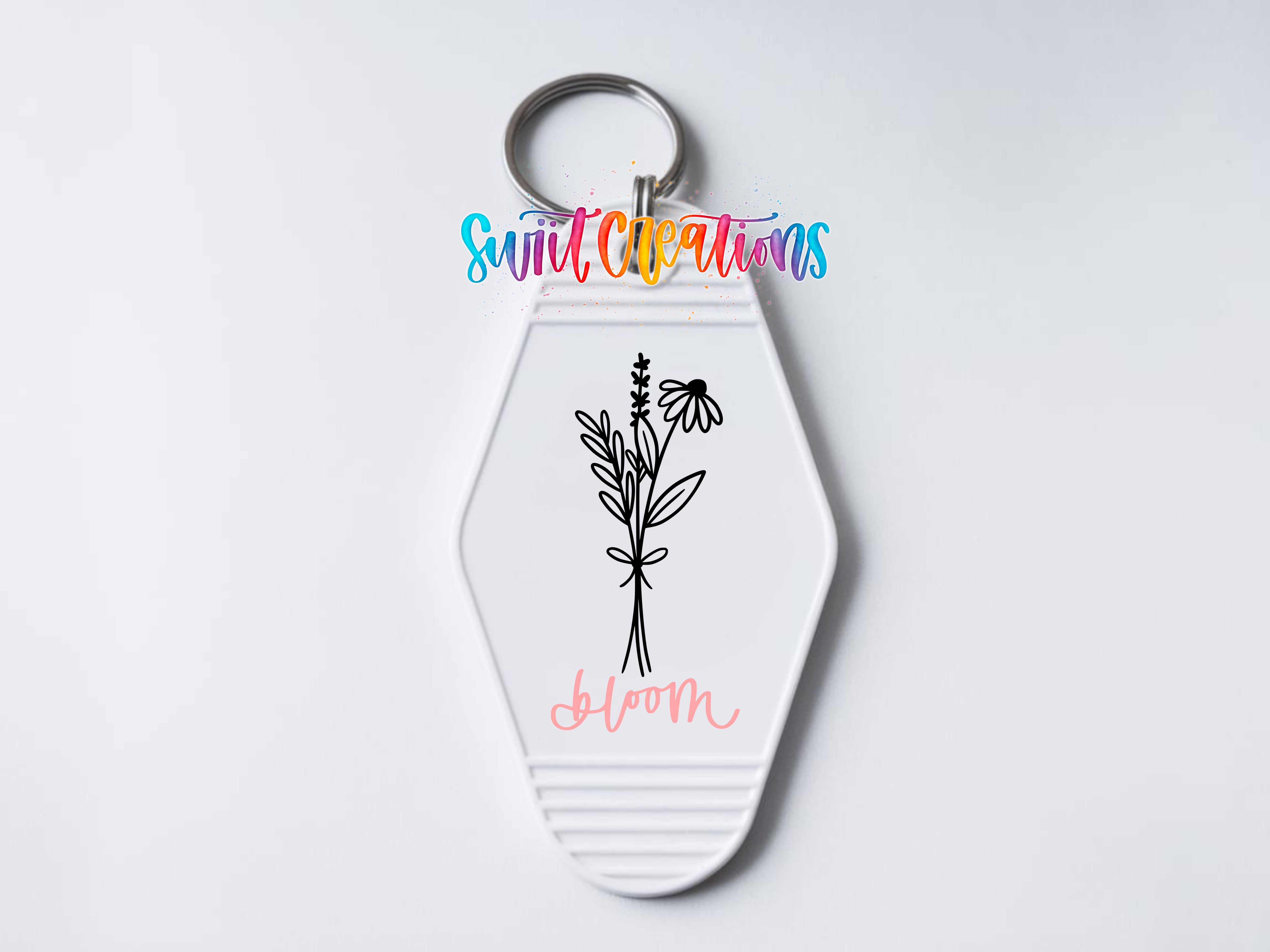 A keychain with a floral design and the word "Bloom" written on it.
