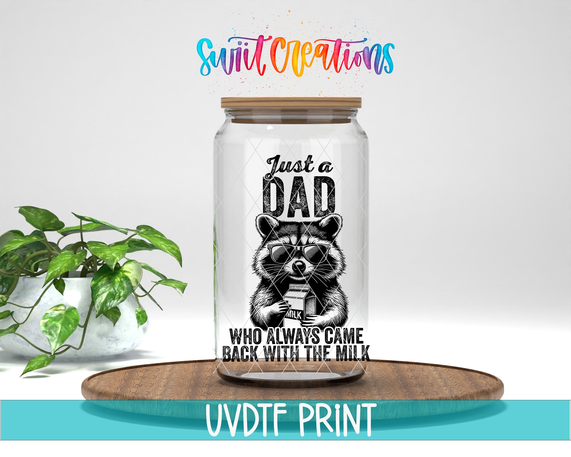 A glass jar with a raccoon image and text, placed on a wooden surface, with a potted plant in the background.