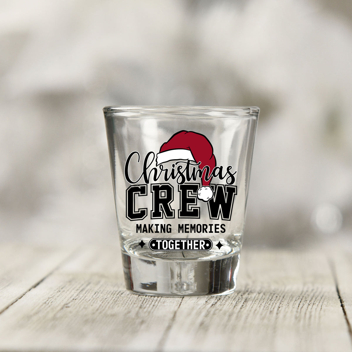 Close-up of the Christmas Crew Making Memories Together UV DTF transfer on a clear shot glass
