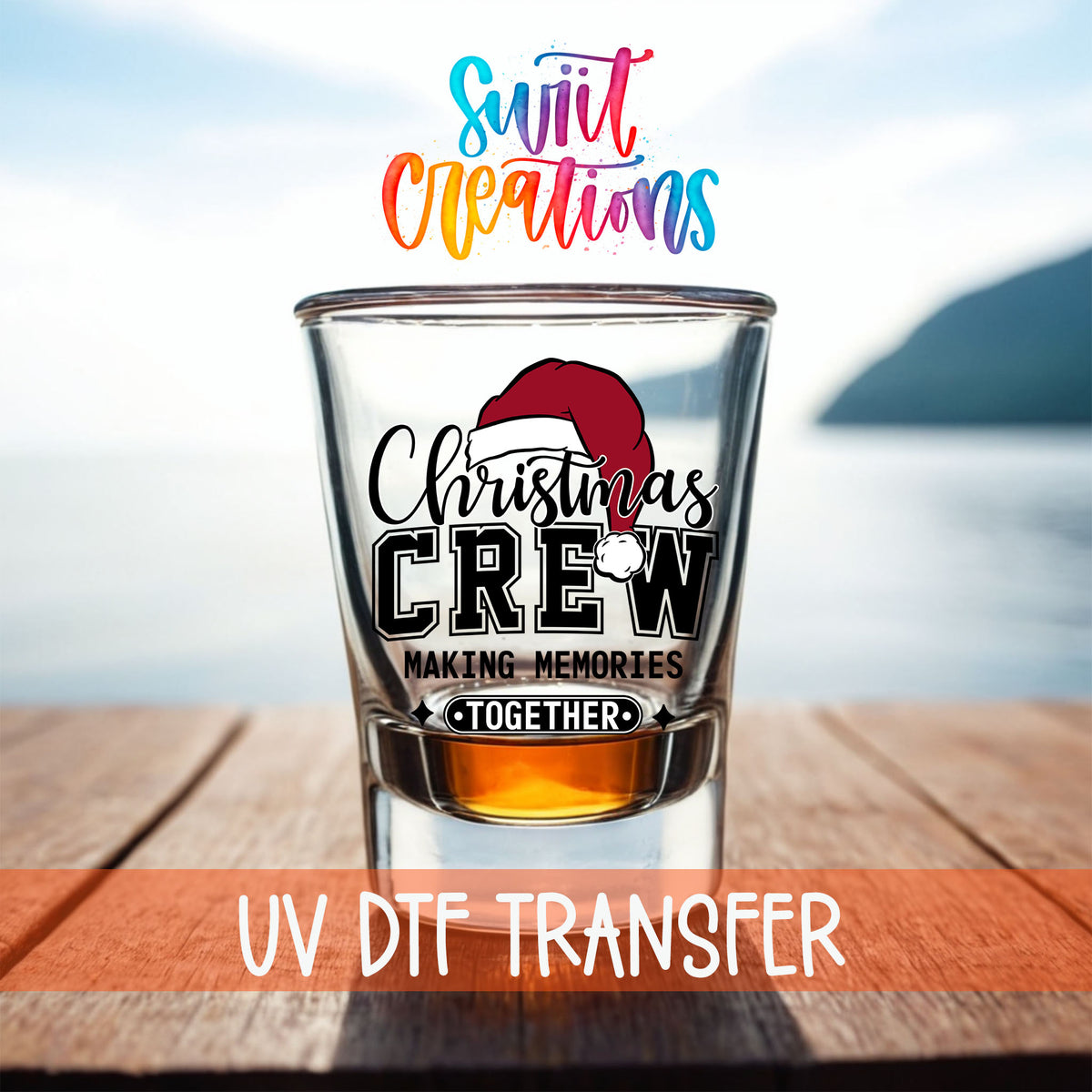 Christmas Crew Making Memories Together shot glass UV DTF transfer on a filled shot glass on a dock by the water