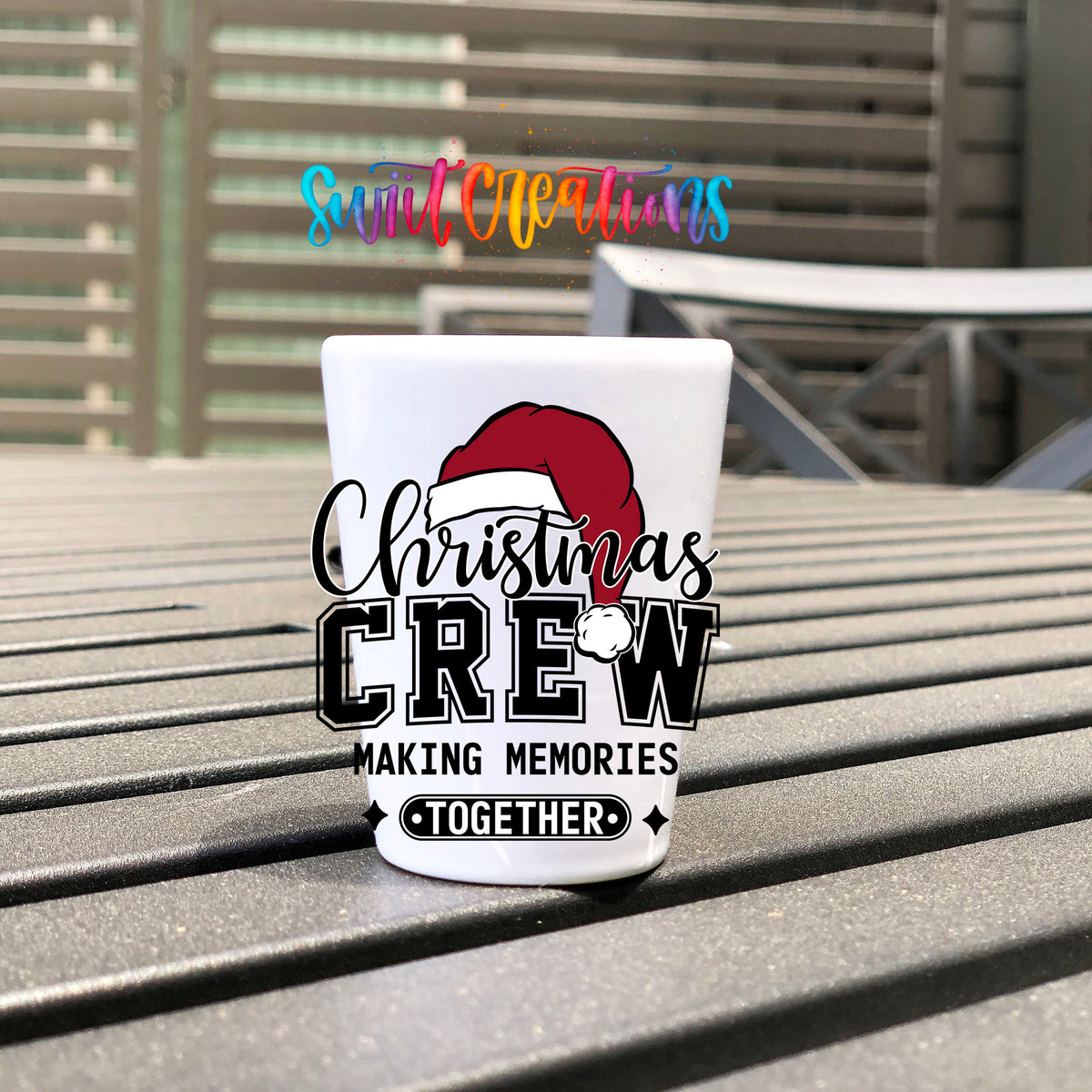 Christmas Crew Making Memories Together UV DTF transfer on a white shot glass on an outdoor patio table