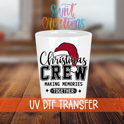 Christmas Crew Making Memories Together shot glass transfer on a white shot glass on a wooden table