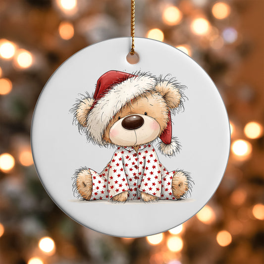 Christmas Pajama Teddy Bear ornament UV DTF transfer on a round white ornament with a bokeh light background