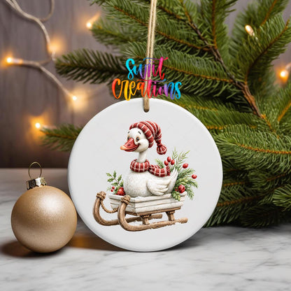 Christmas Sleigh Goose ornament UV DTF transfer on a hanging ornament with pine branches and a gold bauble
