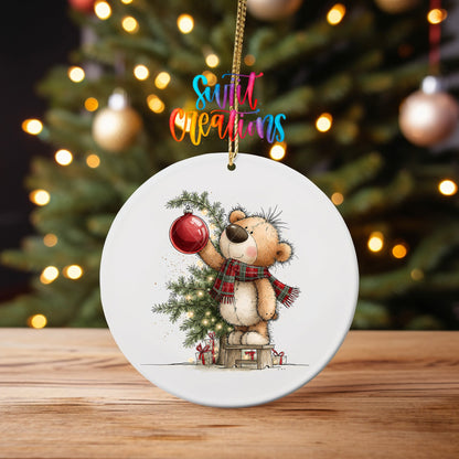 Christmas Tree Teddy Bear ornament UV DTF transfer on an ornament on a wooden table with tree lights behind it