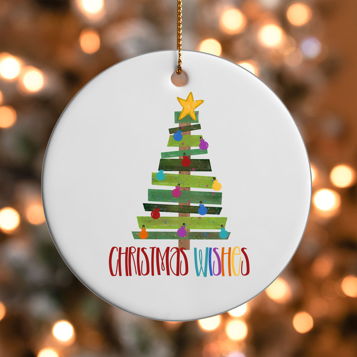 Christmas Wishes Tree ornament UV DTF transfer on a round white ornament with a bokeh light background