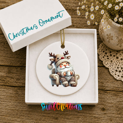 cozy Santa in a reindeer hat relaxing with a mug ceramic Christmas ornament displayed in the included gift box