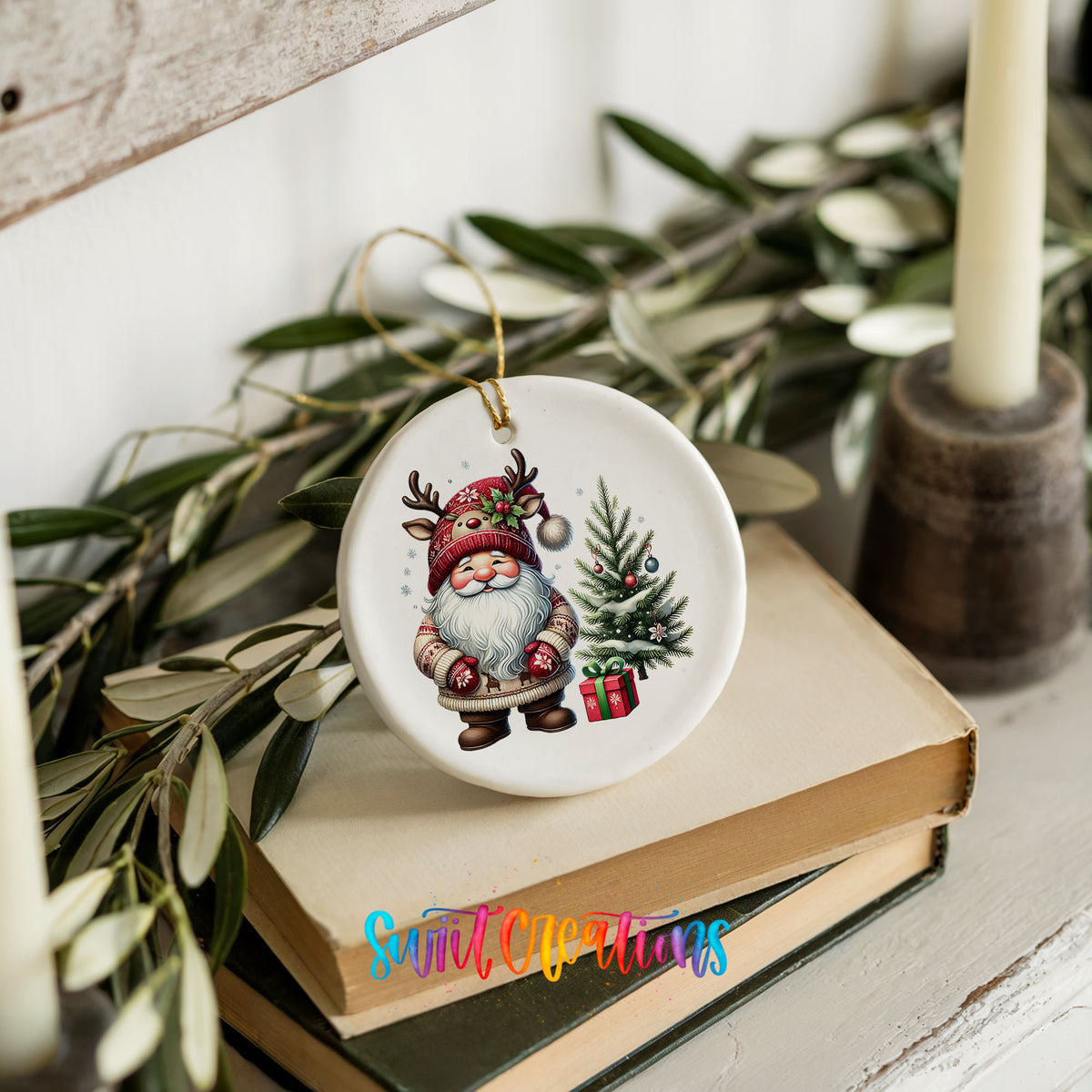 Santa beside a Christmas tree and wrapped gift ceramic Christmas ornament styled on books with holiday greenery
