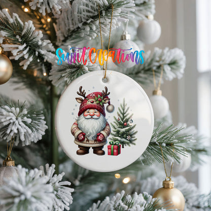 Santa beside a Christmas tree and wrapped gift ceramic Christmas ornament hanging on a frosted Christmas tree