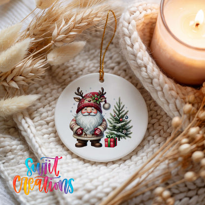 Santa beside a Christmas tree and wrapped gift ceramic Christmas ornament styled beside a candle and cozy knit blanket