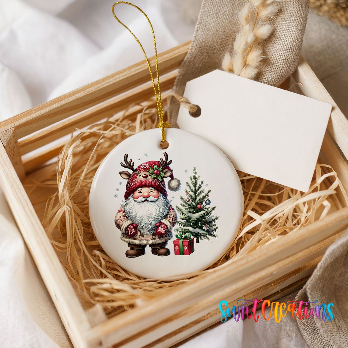 Santa beside a Christmas tree and wrapped gift ceramic Christmas ornament displayed in a rustic wooden gift crate